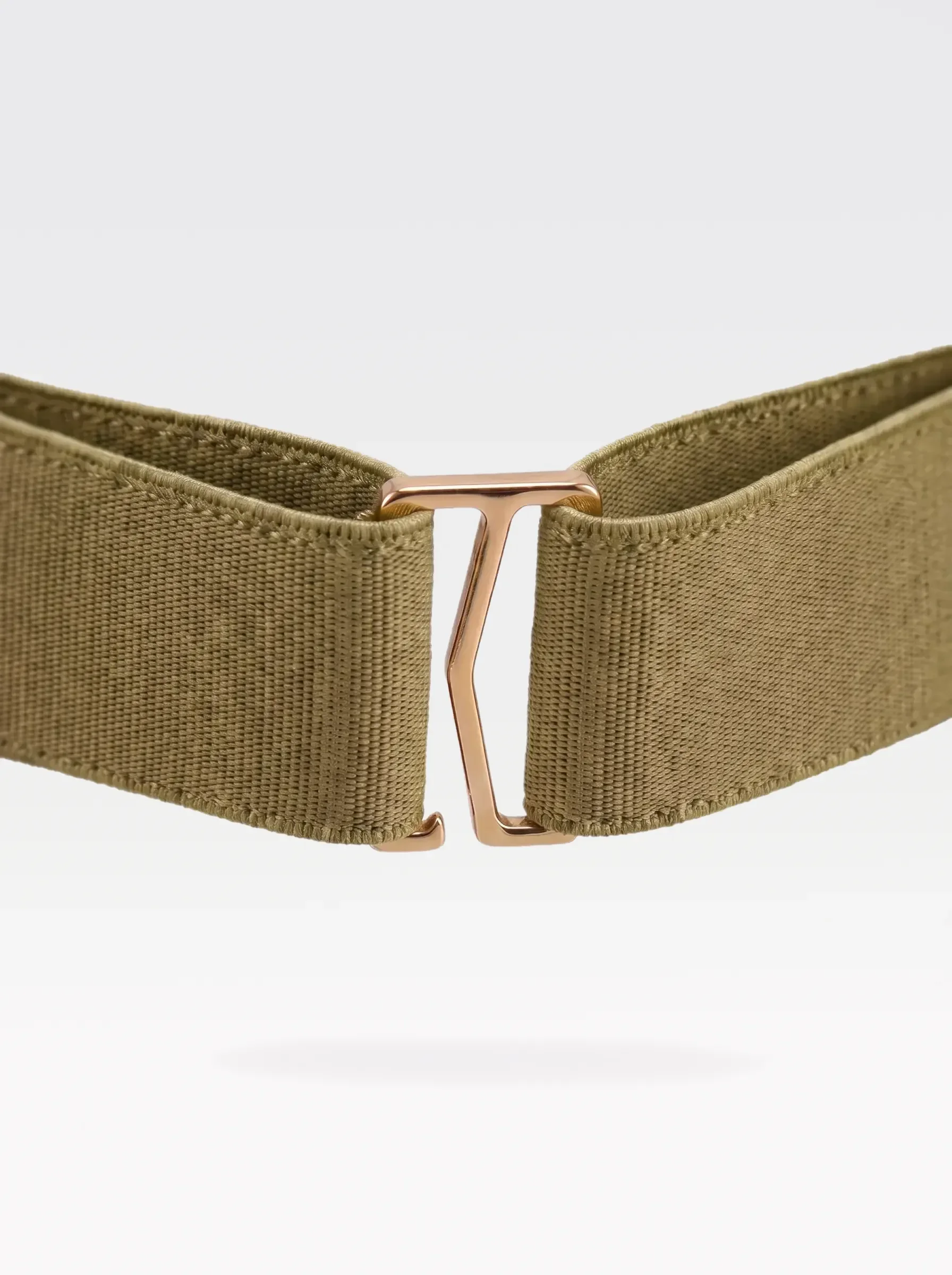 Close-up of the 24K gold-plated brass G hook closure on the pistachio elastic band of a Sainte Sve Belt Croc