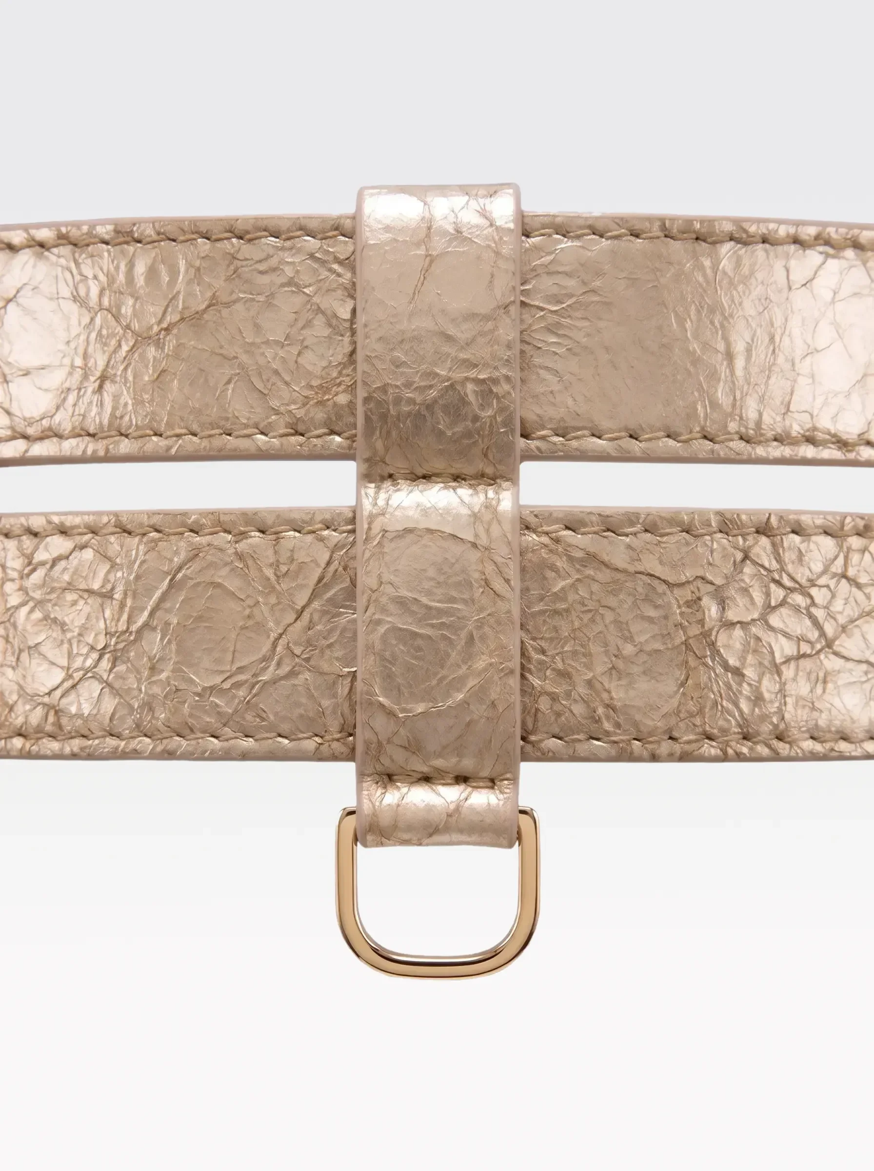 Close-up of the 24K gold-plated brass D ring on the gold laminated lambskin double band of the Sainte Sve Belt Laminated