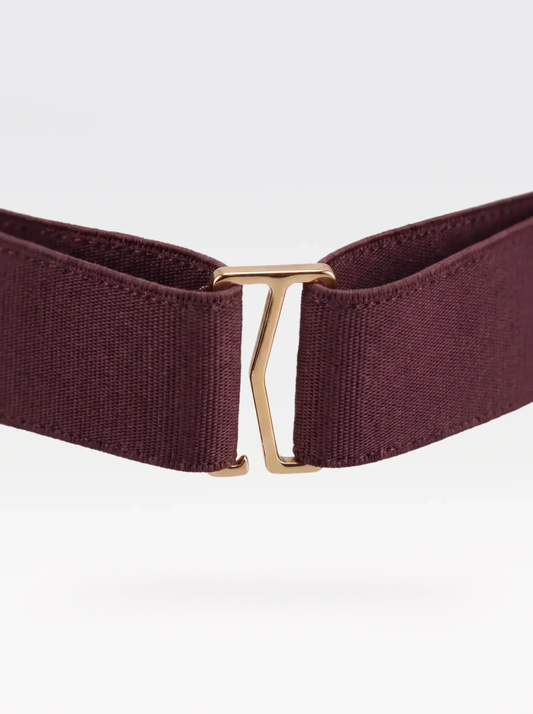 Close-up of the 24K gold-plated brass G hook closure on the burgundy elastic band of a Sainte Sve Belt Croc