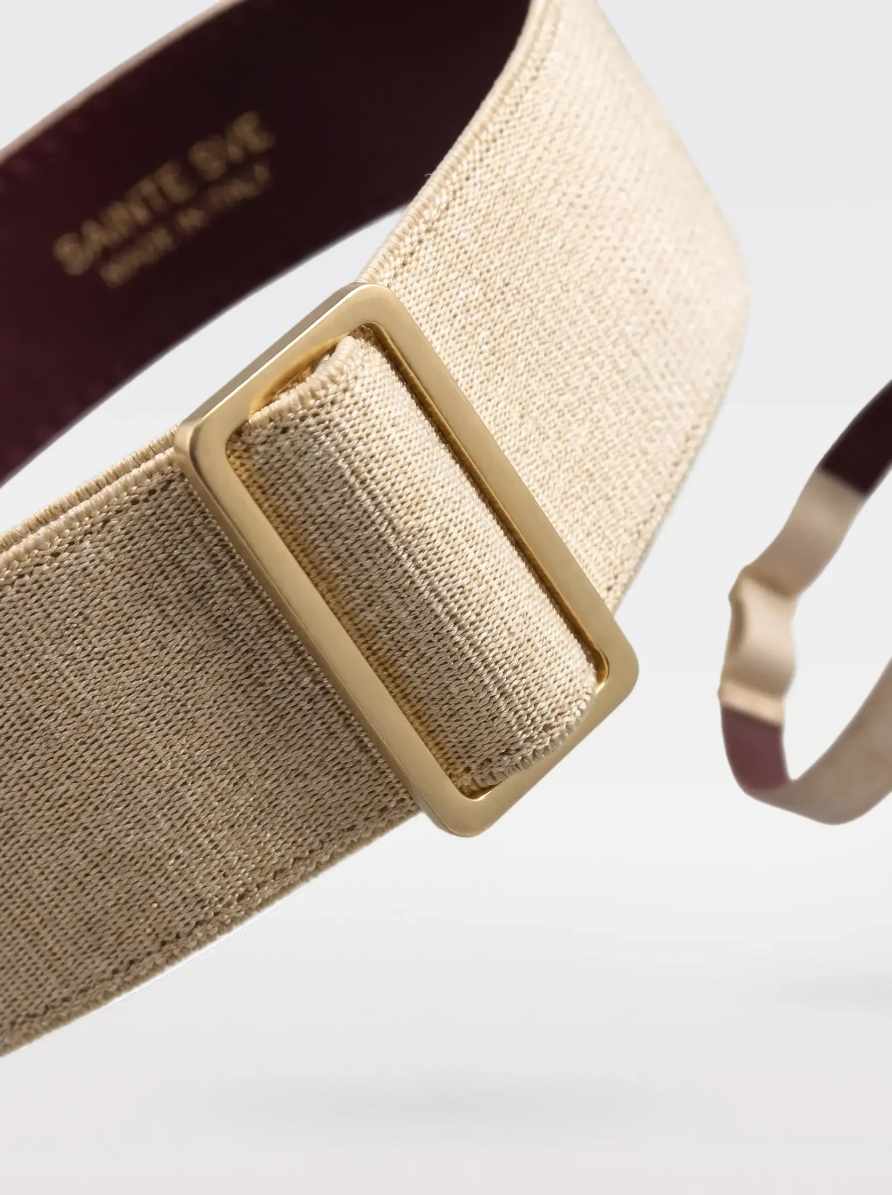 Close-up of the 24K gold-plated brass slider on the gold elastic band of a Sainte Sve Garters Laminated