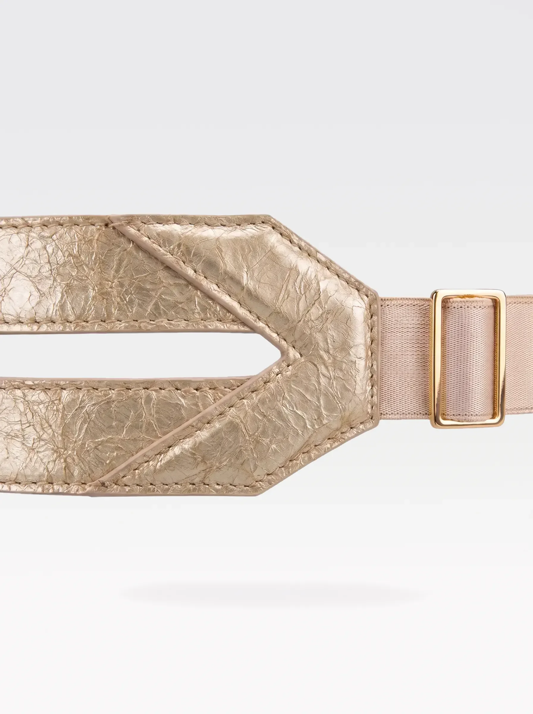 Close-up of the V-shaped gold laminated lambskin panel and 24K gold-plated brass slider of the Sainte Sve Belt Laminated