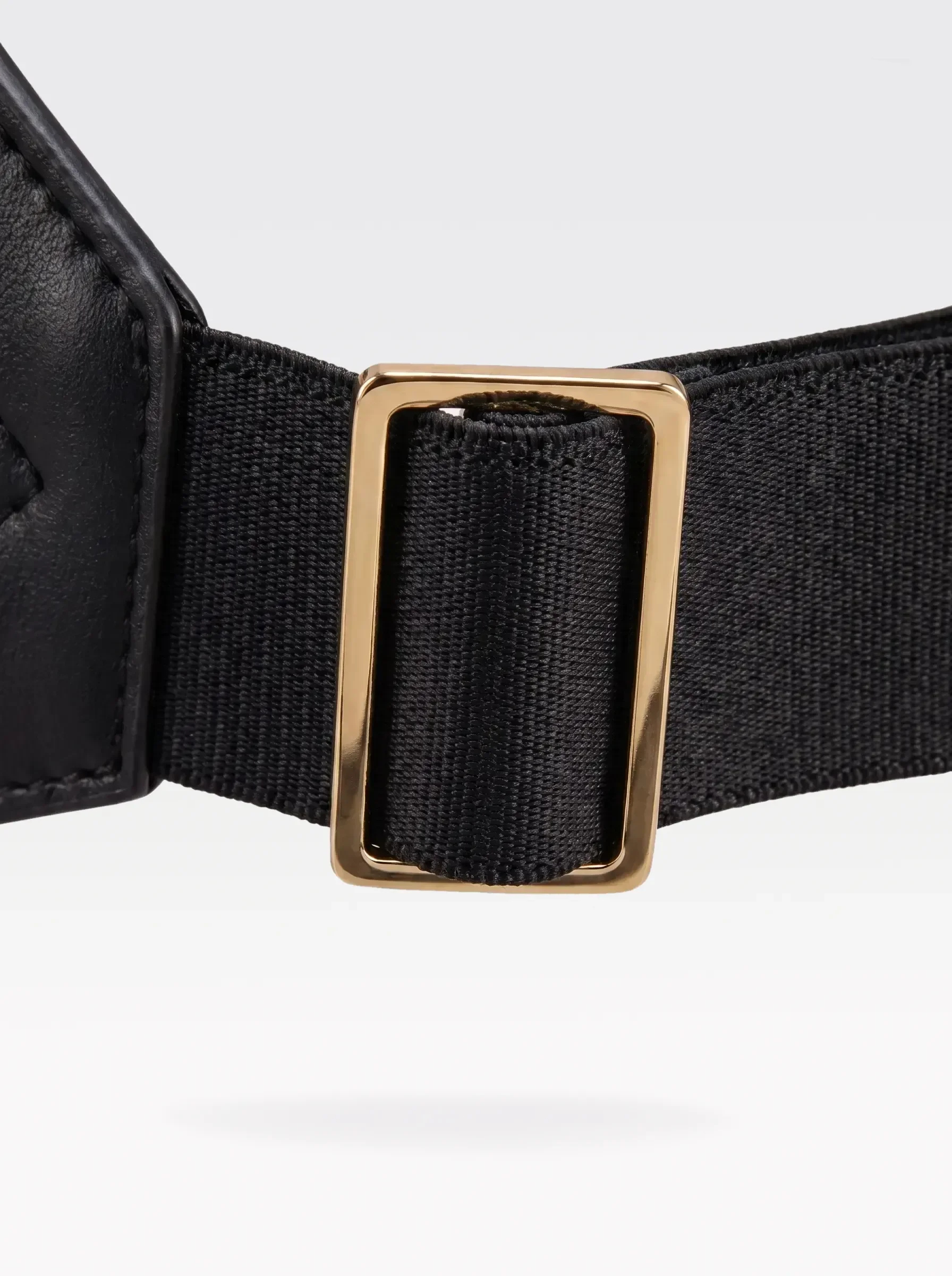 Close-up of the 24K gold-plated brass slider on the black elastic band of a Sainte Sve Belt Nappa