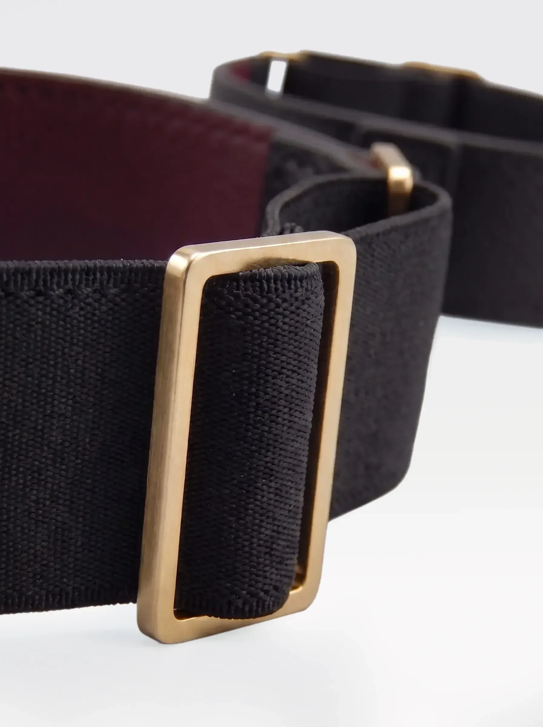 Close-up of the 24K gold-plated brass slider on the black elastic band of a Sainte Sve Arm Bracelets Nappa