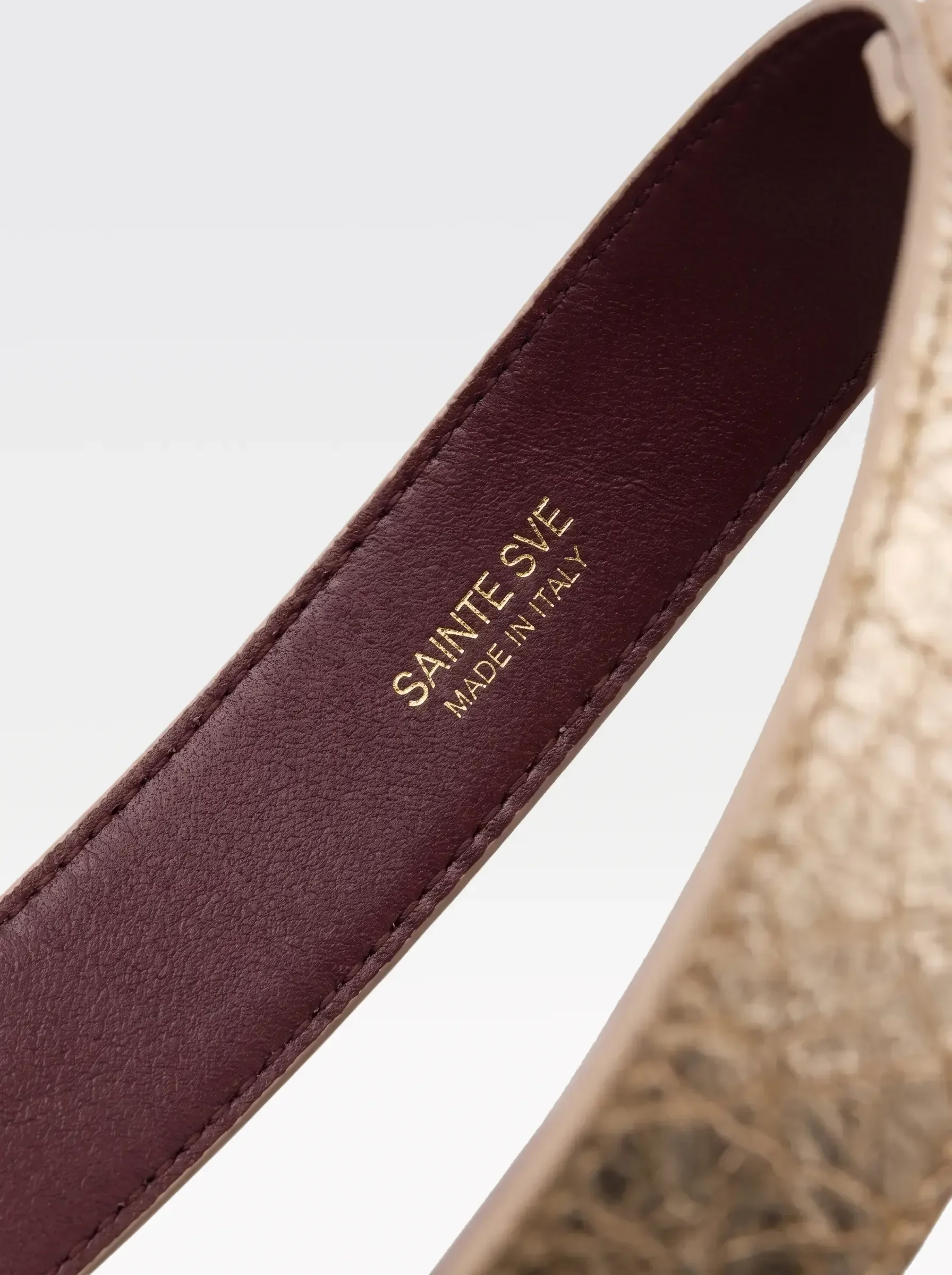 Close-up of the burgundy nappa lambskin lining of the Sainte Sve Garters Laminated with the foil-stamped Sainte Sve Made in Italy logo