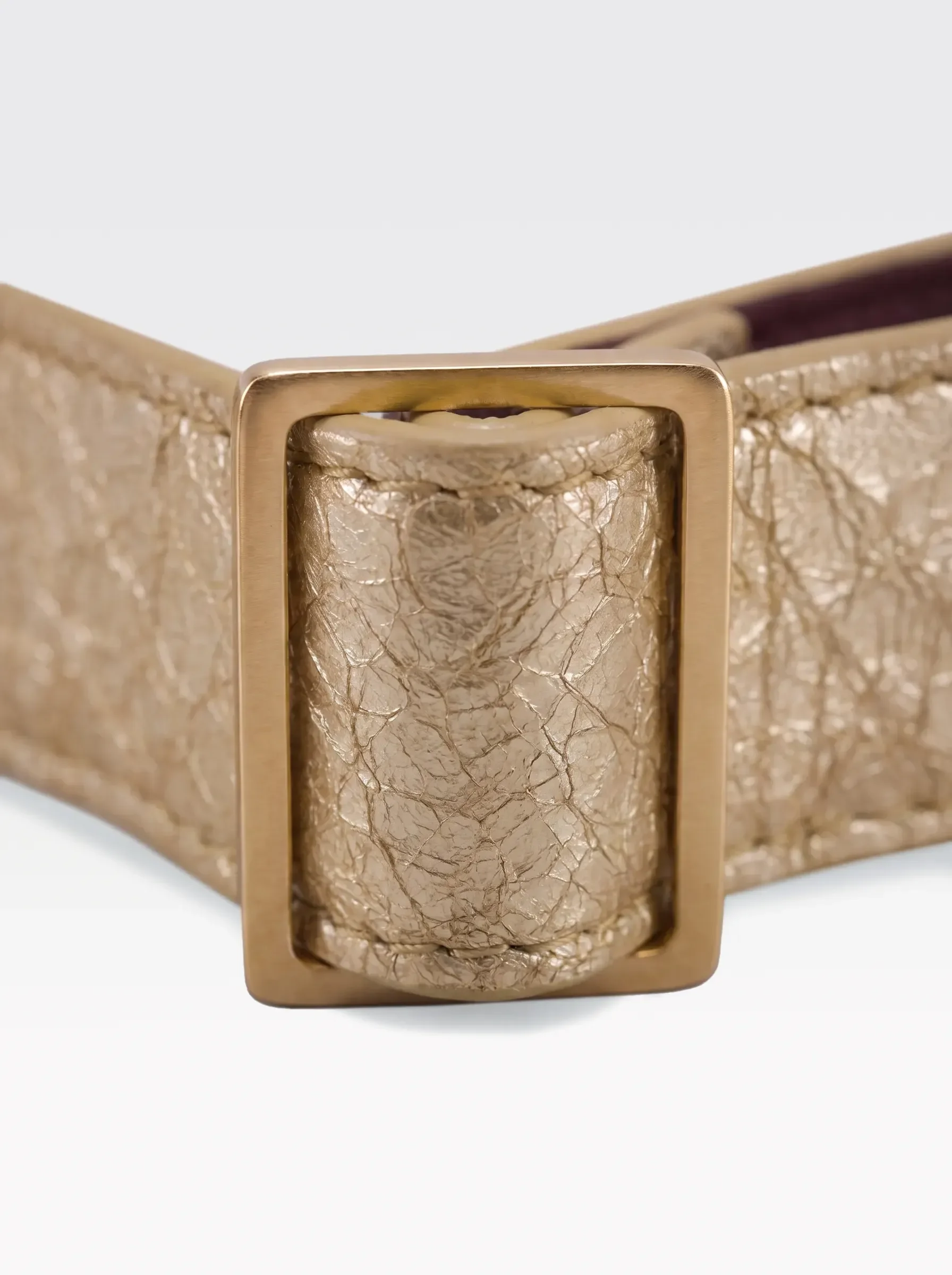 Close-up of the 24K gold-plated brass slider on the gold laminated lambskin of a Sainte Sve Choker Laminated