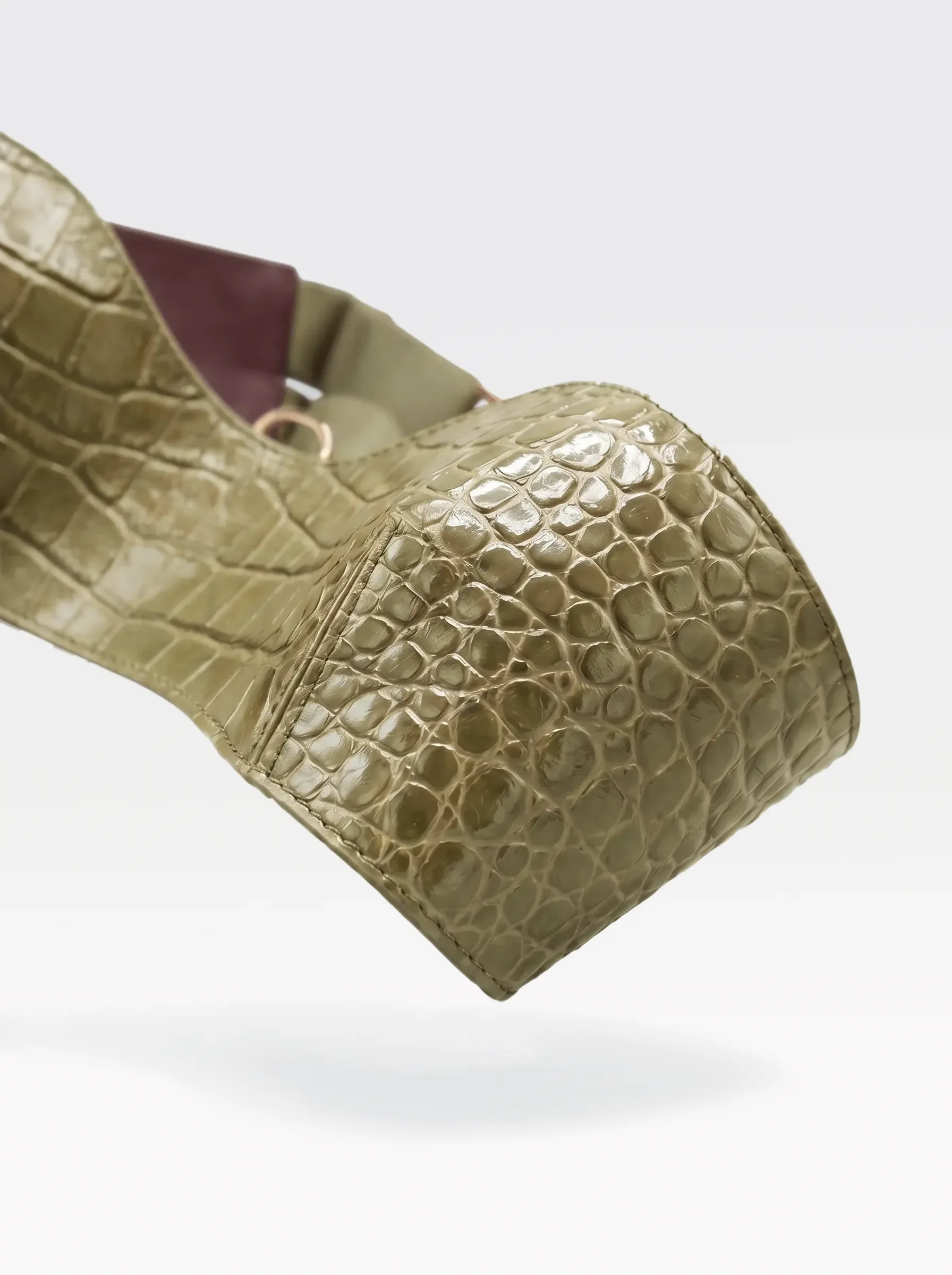 Close-up of the pistachio crocodile-embossed lambskin band with a 24K gold-plated brass eyelet of the Sainte Sve V.N.V Croc