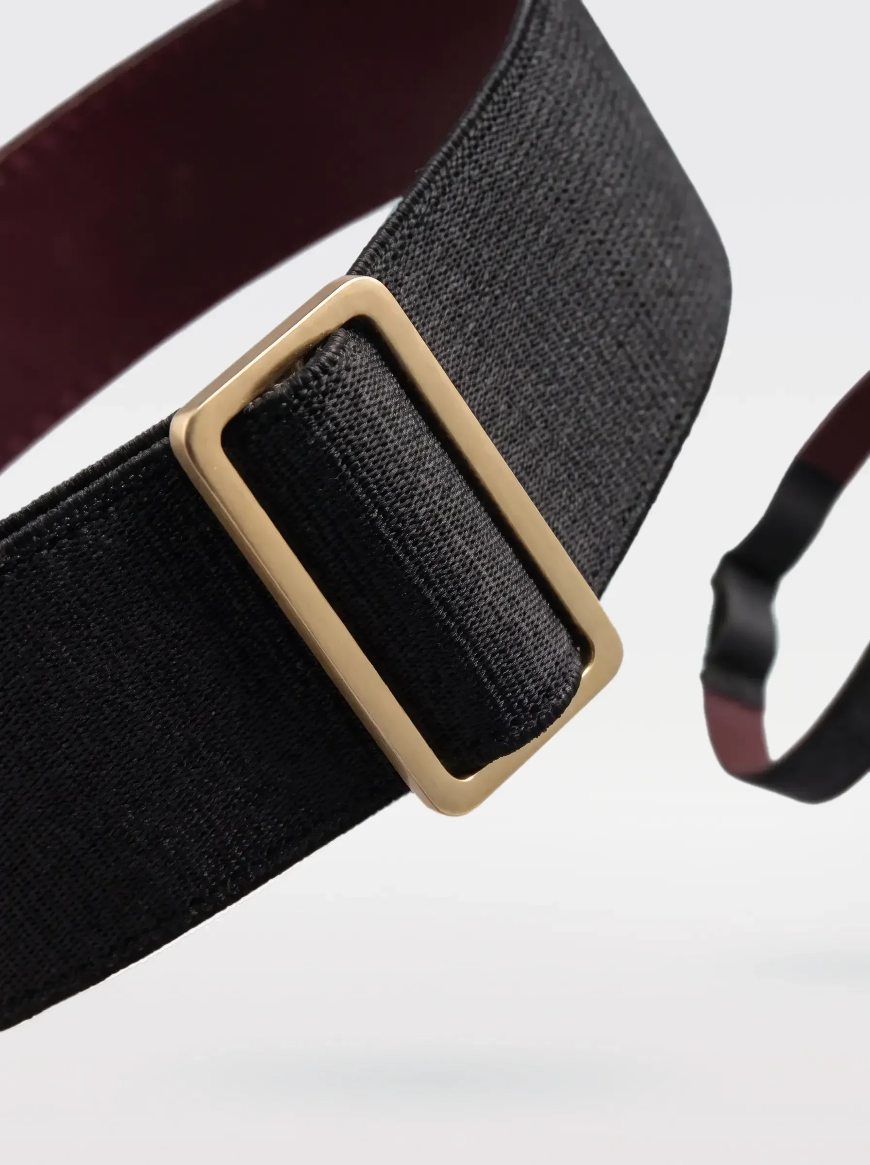 Close-up of the 24K gold-plated brass slider on the black elastic band of a Sainte Sve Garters Nappa
