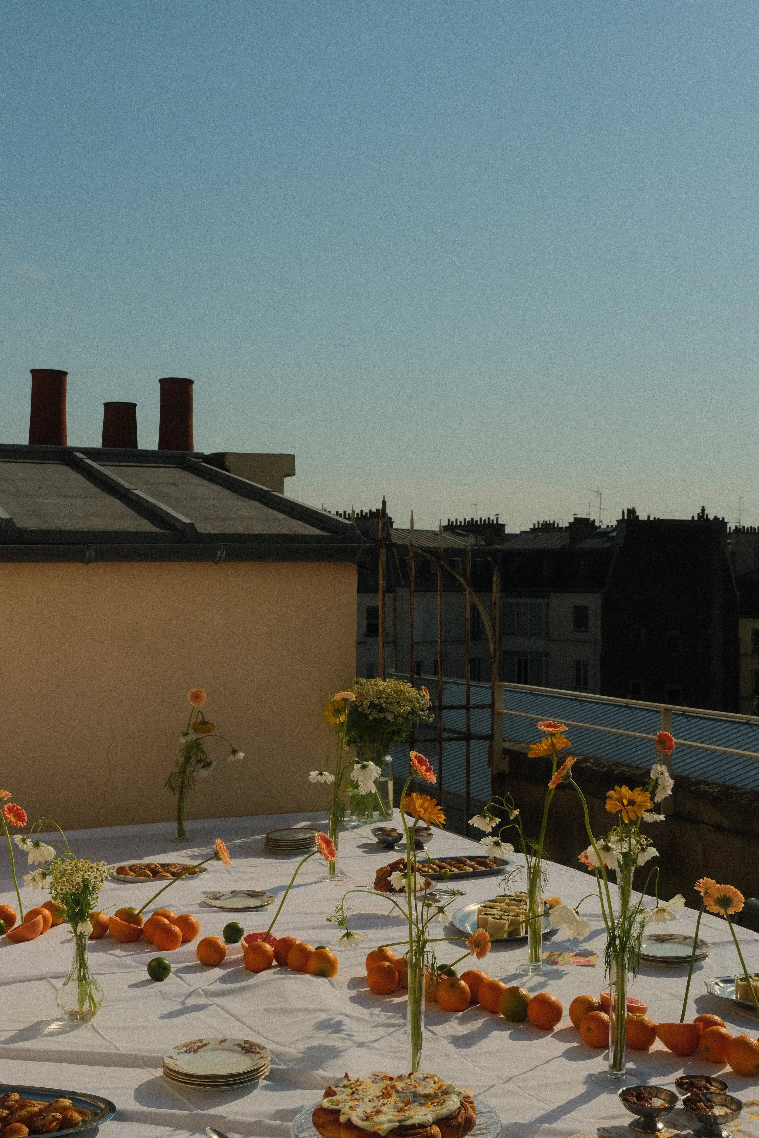 Grande tablée dressée pour un événement, avec plats à partager et fleurs fraîches