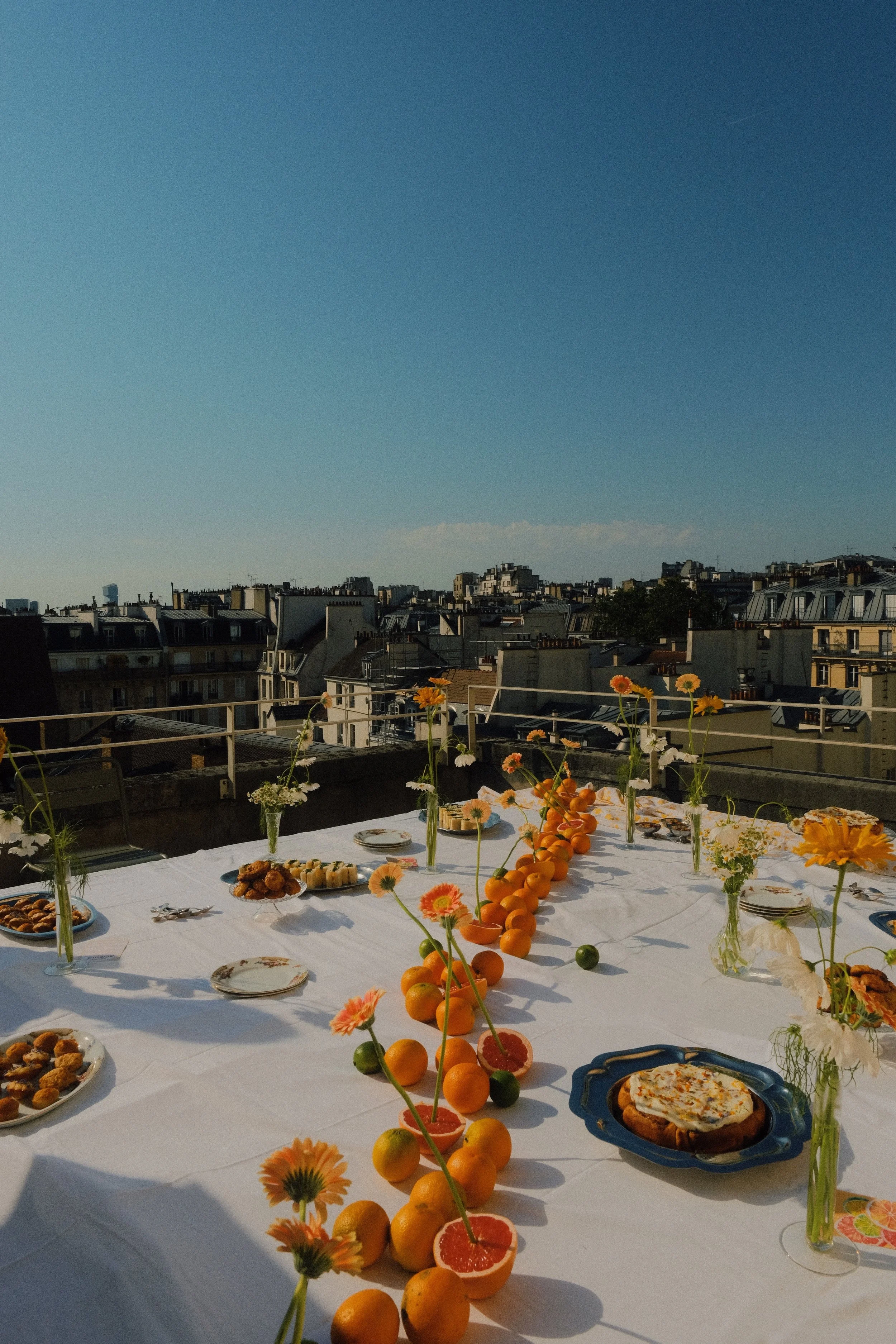 Grande tablée dressée pour un événement, avec plats à partager et fleurs fraîches