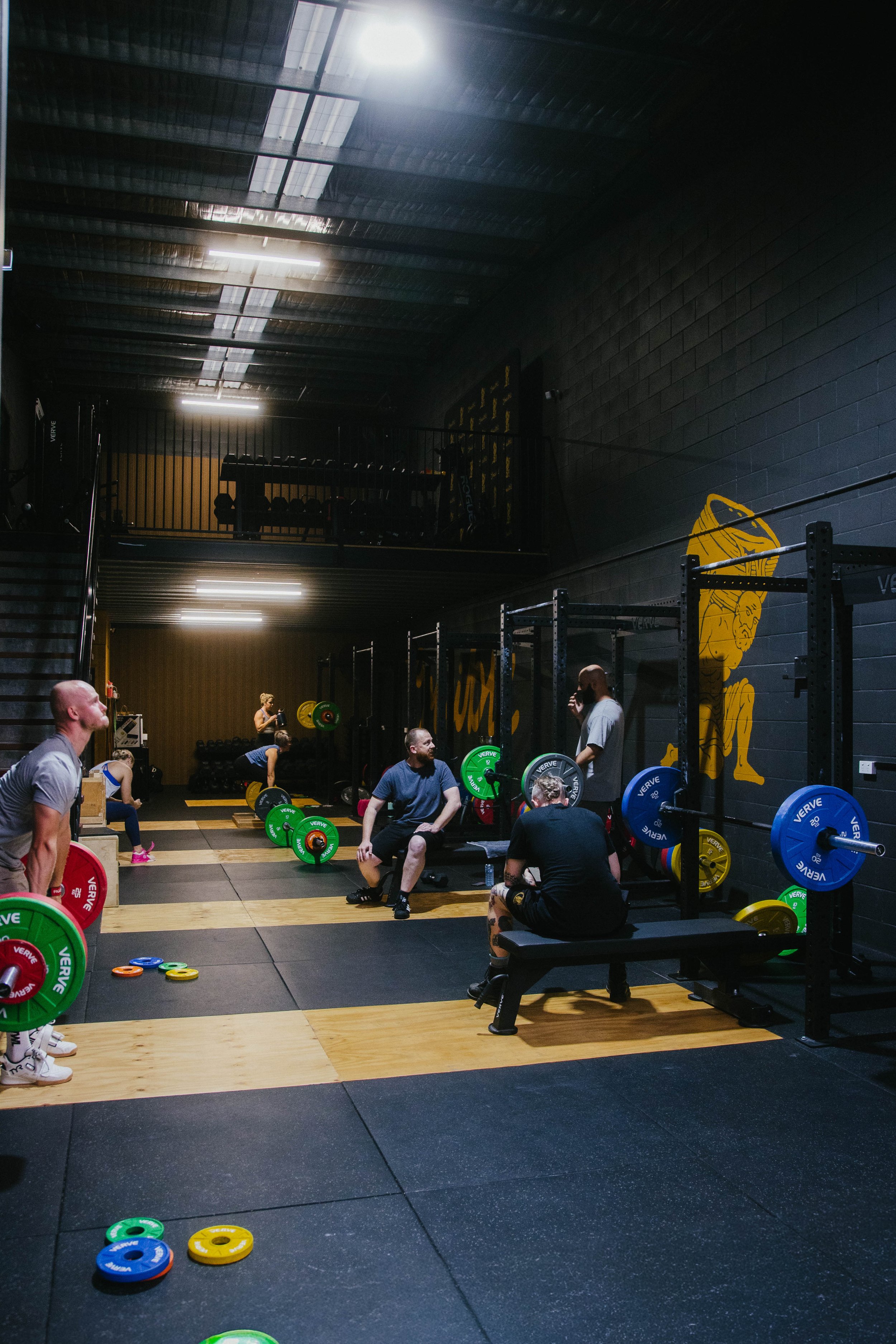 Small-group class at Crucible Strength with members following different training programs under coach supervision