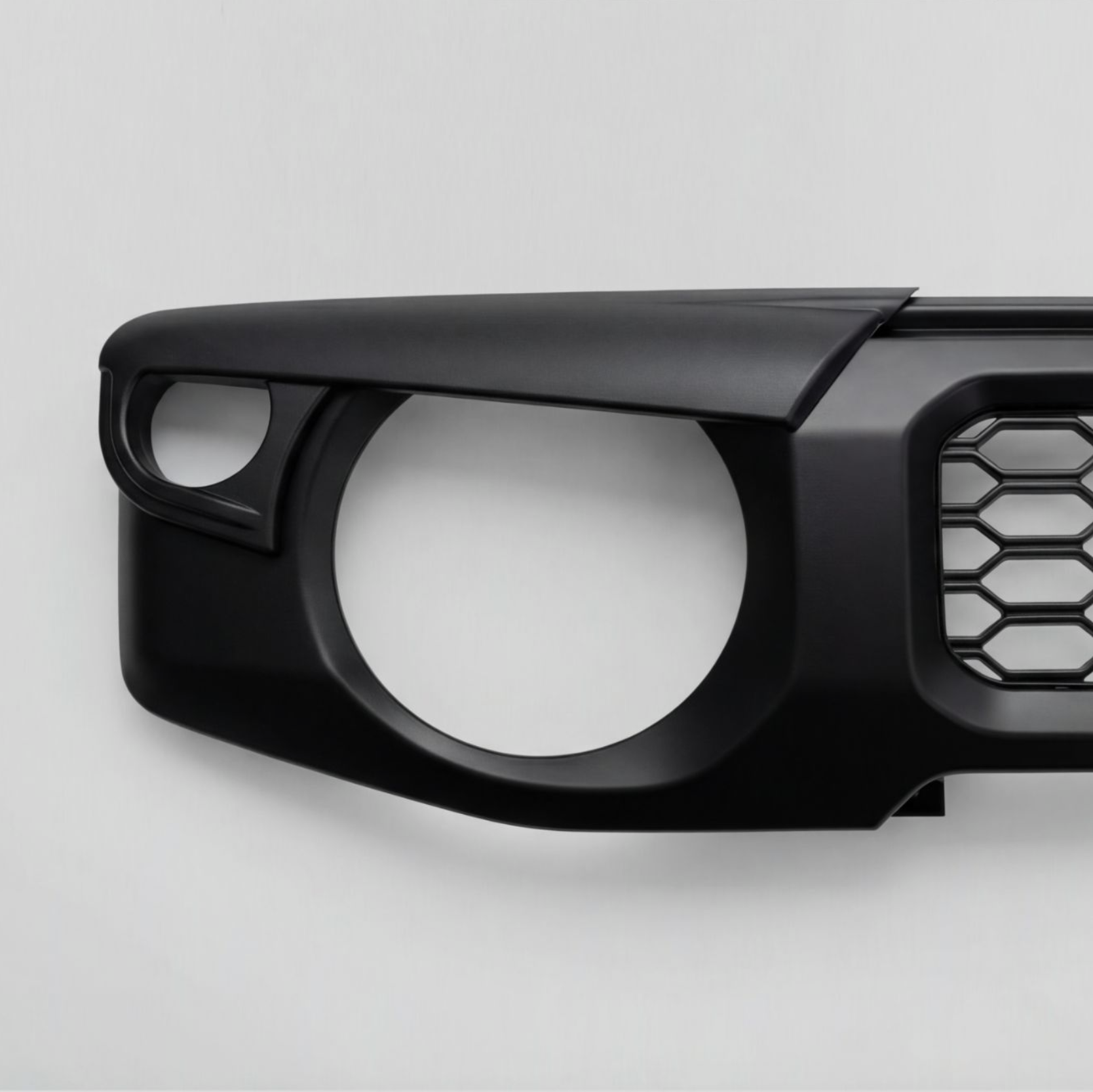 Close-up of a black vehicle front bumper with an air intake grille on a plain white background.