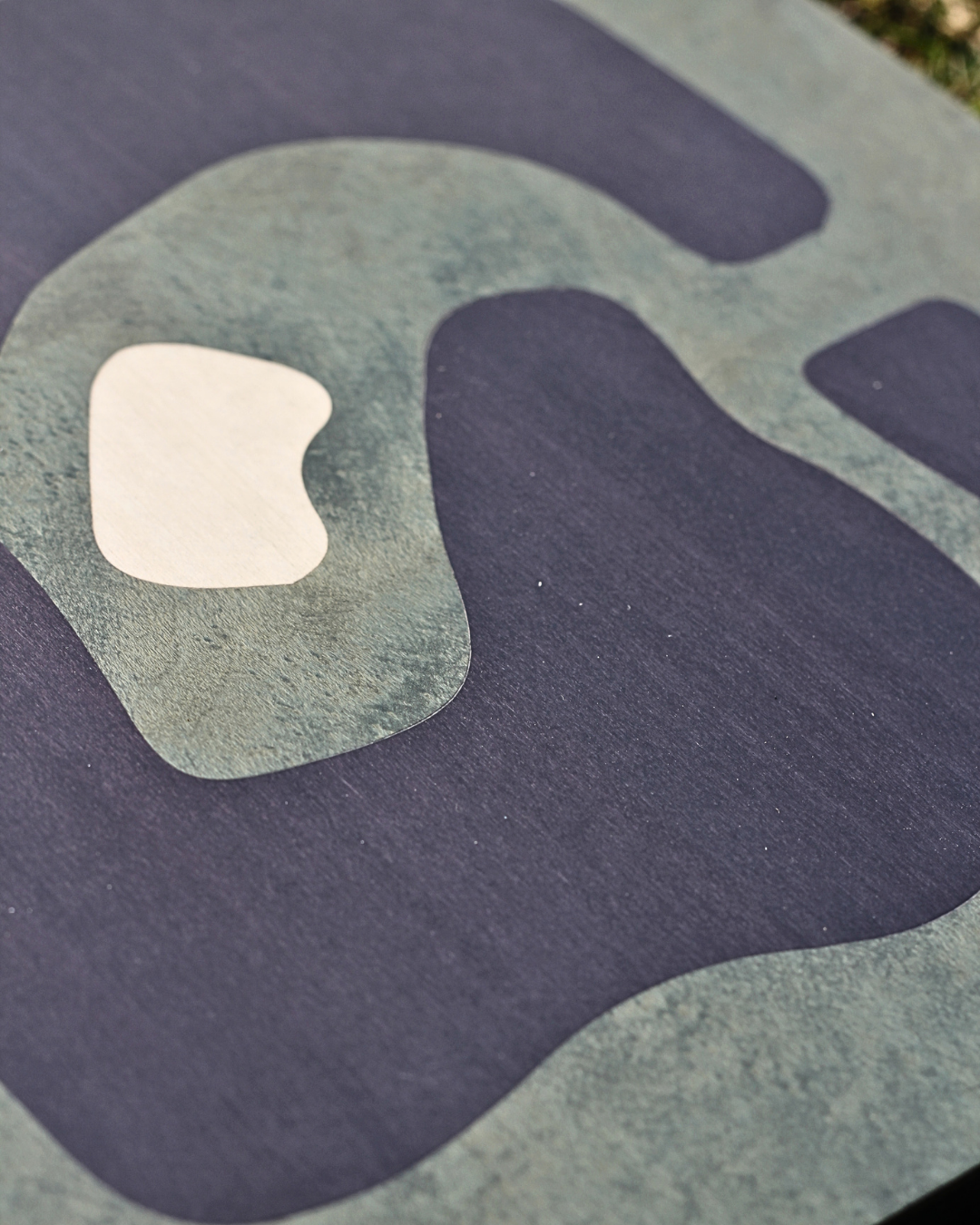 Close-up of a printed image showing the Instagram logo in muted green and white colors on a dark background.