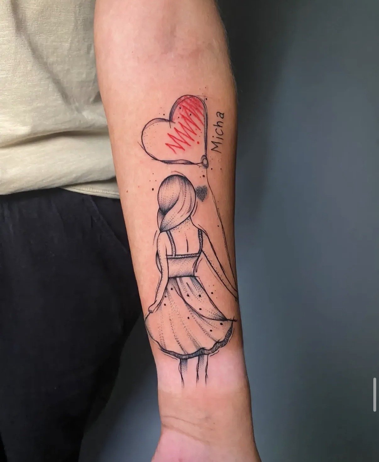 Tatoo eines Mädchens mit langer Haar, das ein Kleid trägt, auf dem Unterarm.