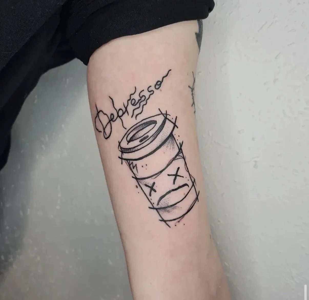 Tattoo auf dem Oberschenkel mit der Darstellung einer Tablette und dem Wort 'Jeunesse' in kalligrafischer Schrift.