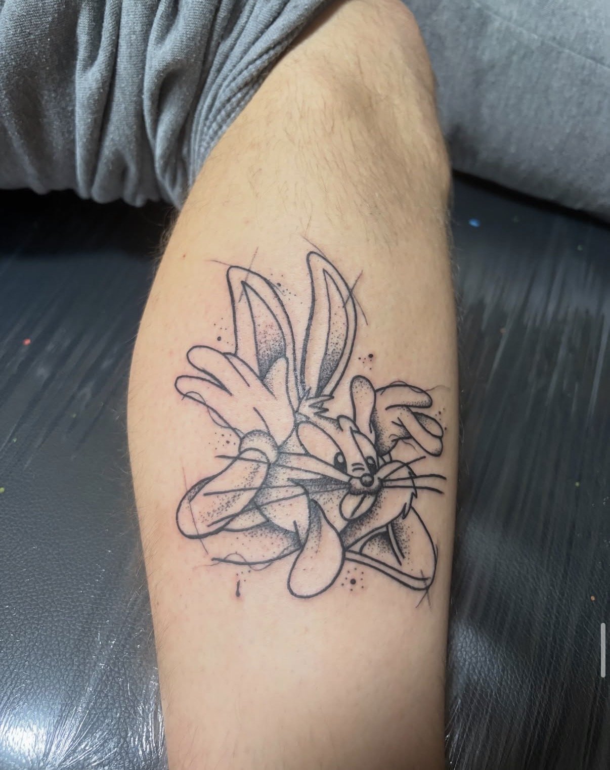 Tattoo eines cartoonhaften Kaninchens auf dem Oberschenkel, das Flügel hat.