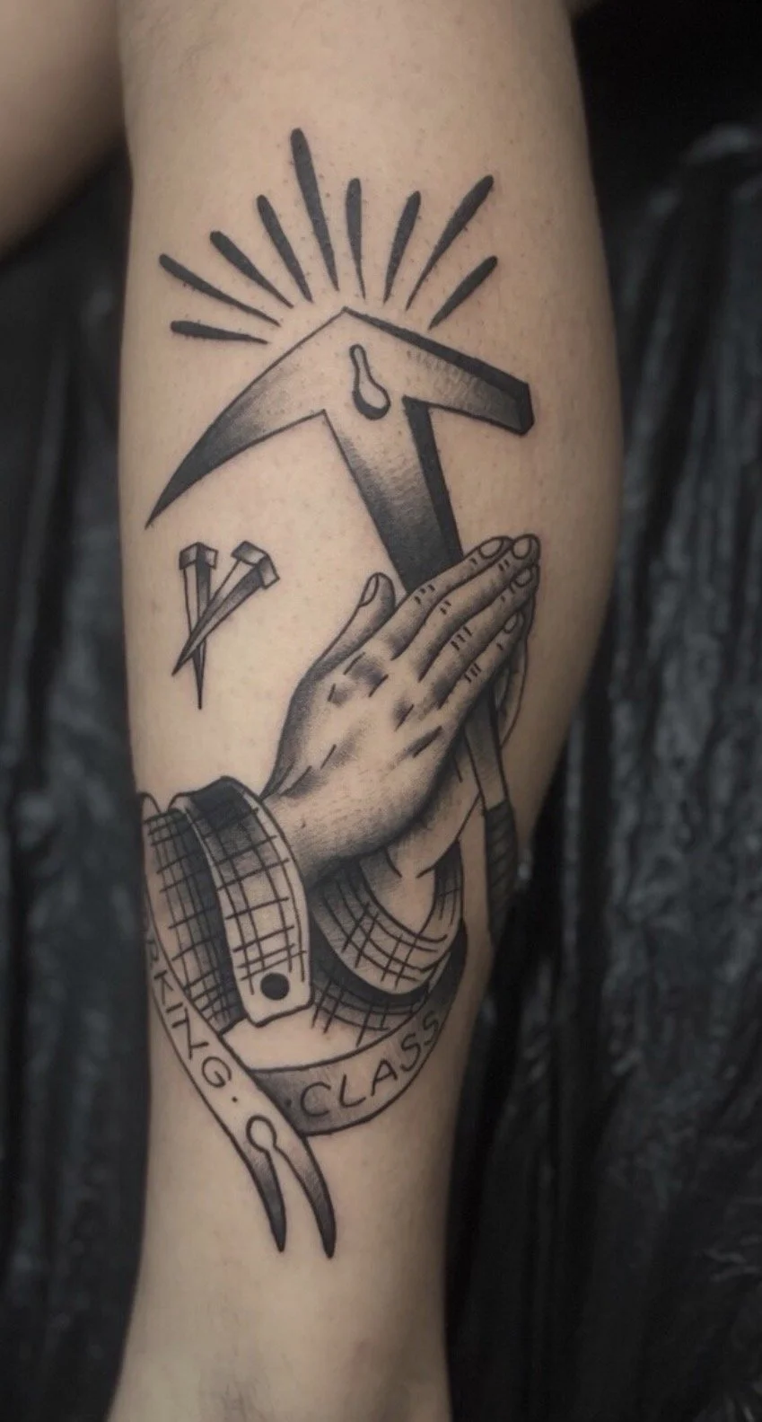 Schwarze Tätowierung eines Hand, die eine Uhr hält, über der sich Sonnenstrahlen ausbreiten, mit mehreren Nägeln und einer Schneiderei-Schere darunter.