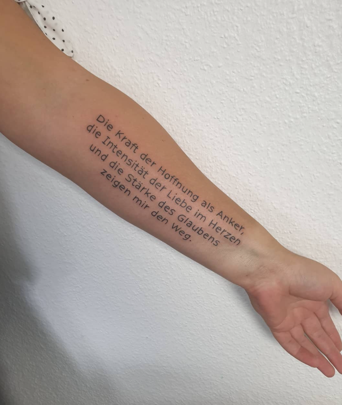 Ein arm mit einem Tattoo, das einen deutschen Text enthält.