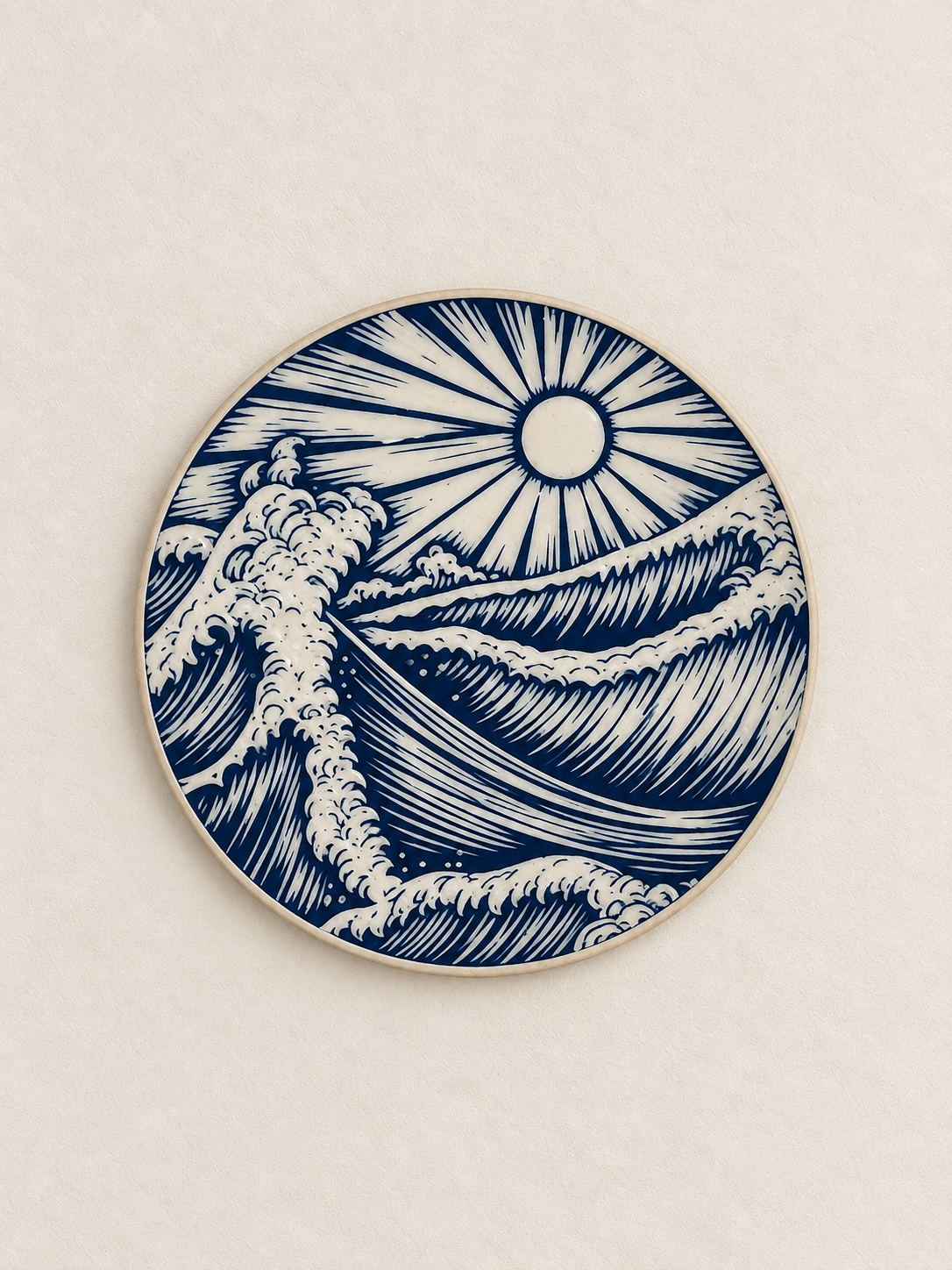 Ceramic plate with a blue and white design depicting ocean waves and the sun.