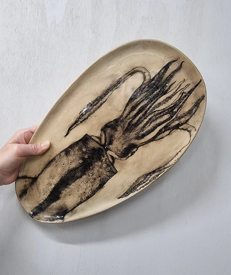 Ceramic platter with a black and beige squid illustration