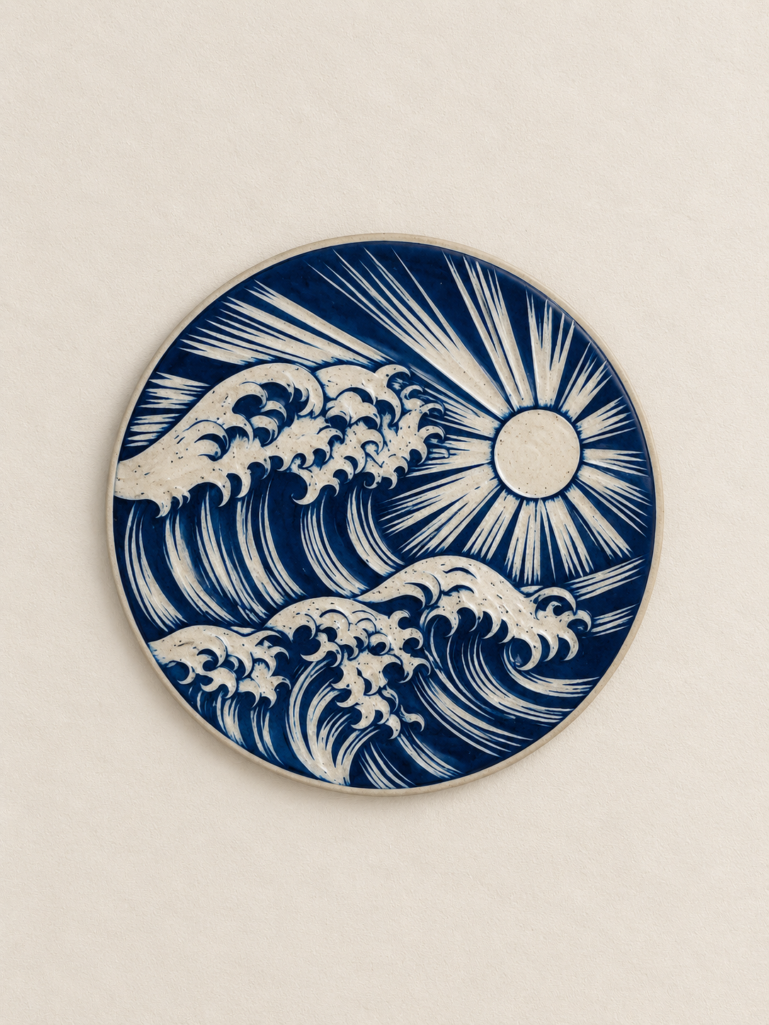 Ceramic plate featuring a blue and white design of waves and a rising sun.
