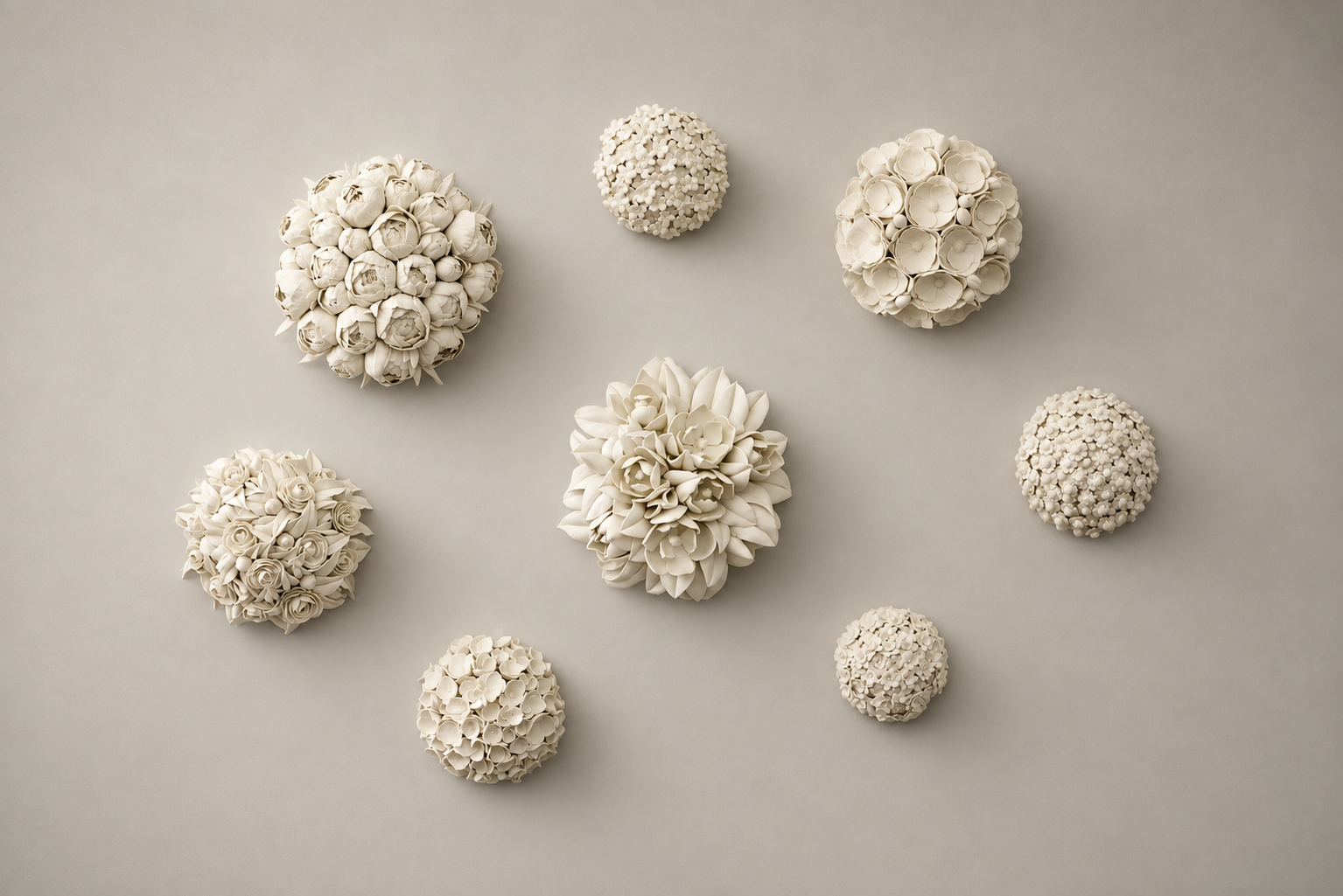Collection of eight ceramic white spherical floral arrangements of various sizes on a light gray background.