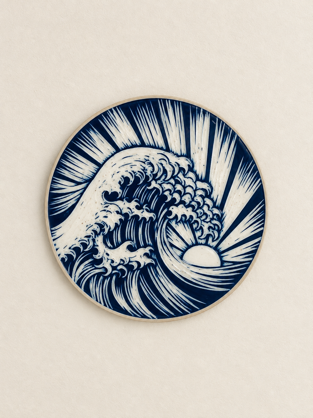 Ceramic plate featuring a stylized blue and white depiction of a giant ocean wave with rising sun in background.
