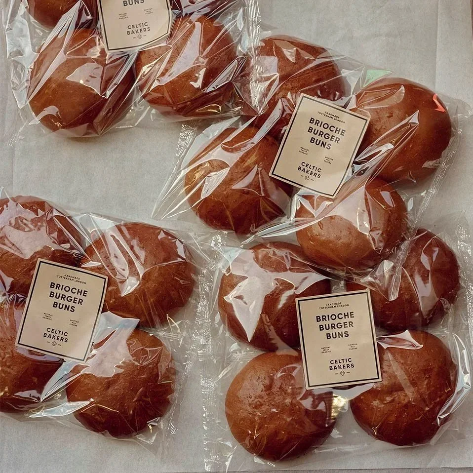 Six individually wrapped brioche burger buns in clear plastic bags with labels from Celtic Bakers.