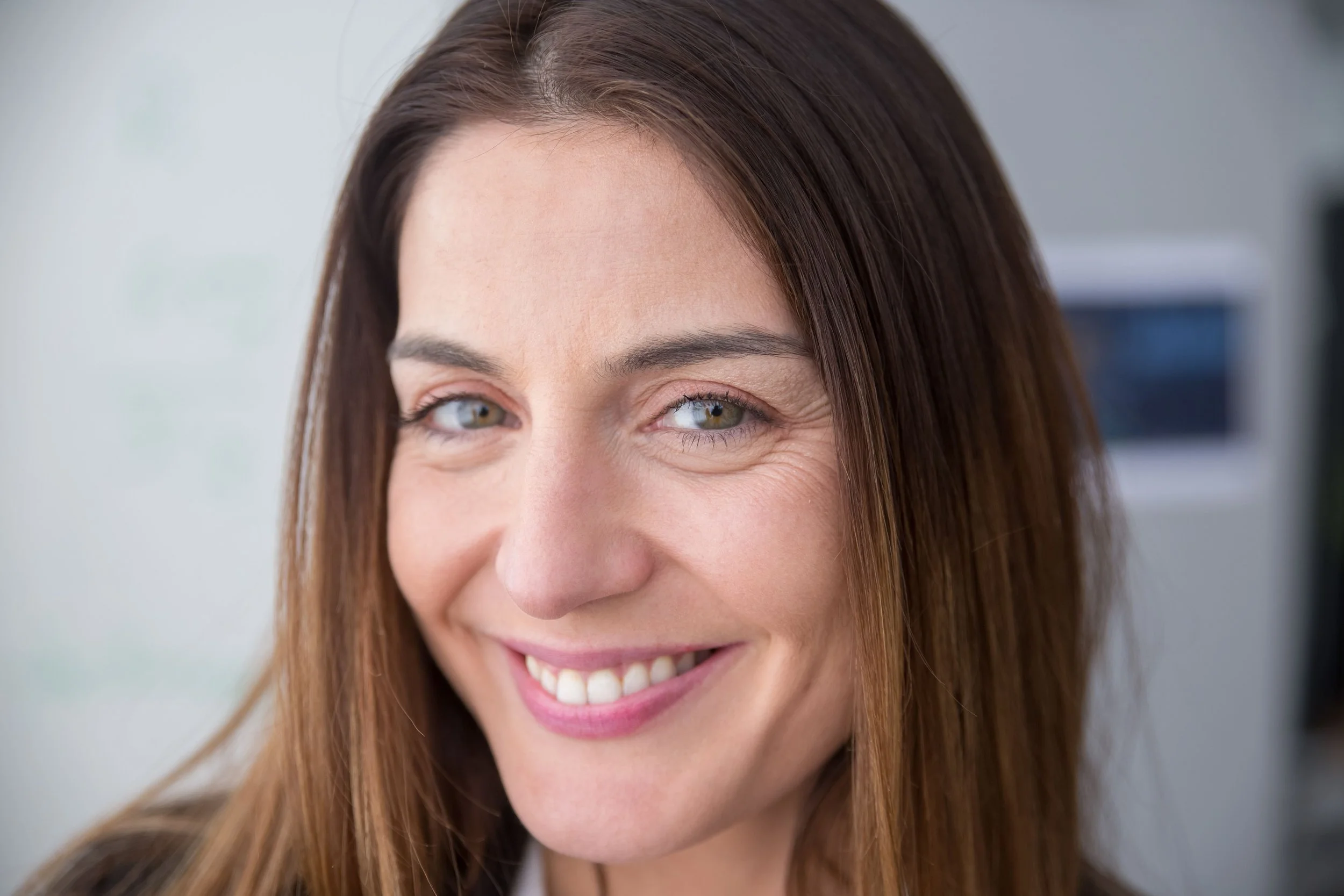 Headshot of smiling female tutor with short blonde hair wearing a lanyard.
