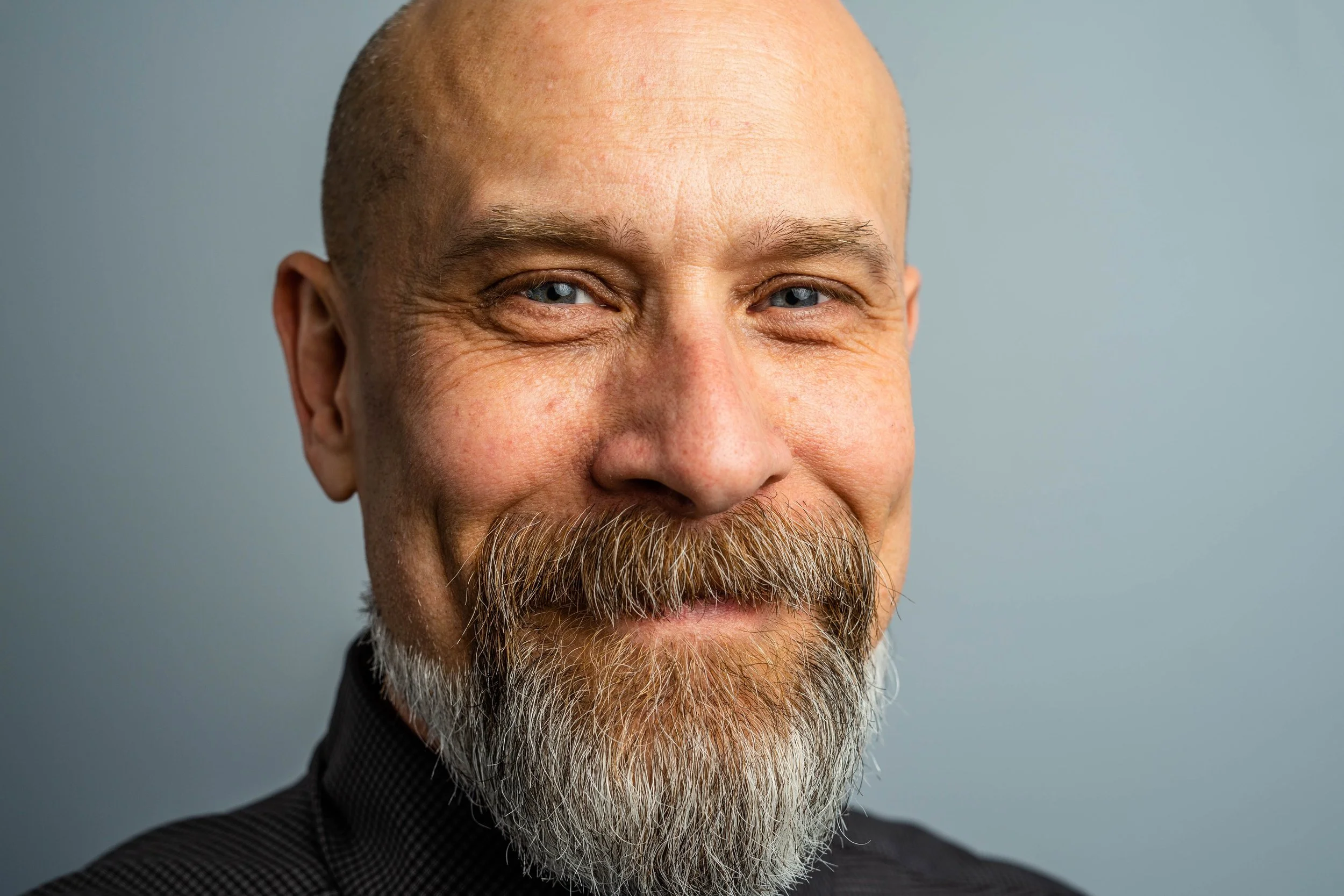 Headshot of smiling male tutor with medium-length black hair wearing a lanyard.