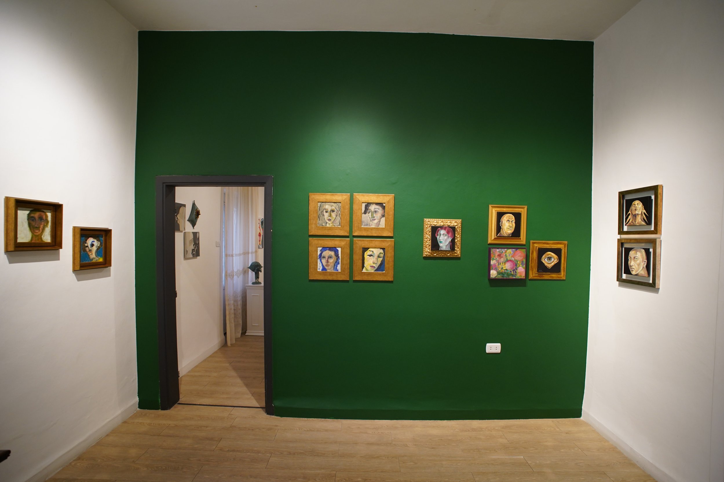   Miniature artworks displayed on the green wall at Q0DE Art Space during the “Miniatures” group exhibition.   14 July 2026 © Photo by Yasr Abdalla  