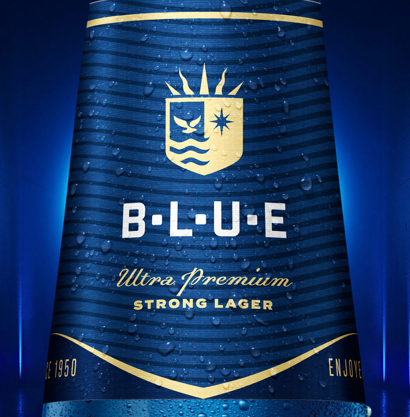 A blue bottle of Carib Blue Ultra Premium Strong Lager beer with water droplets on the surface, featuring a gold and white label with a crest-like emblem and the words "Blue Ultra Premium Strong Lager" in gold and white text.