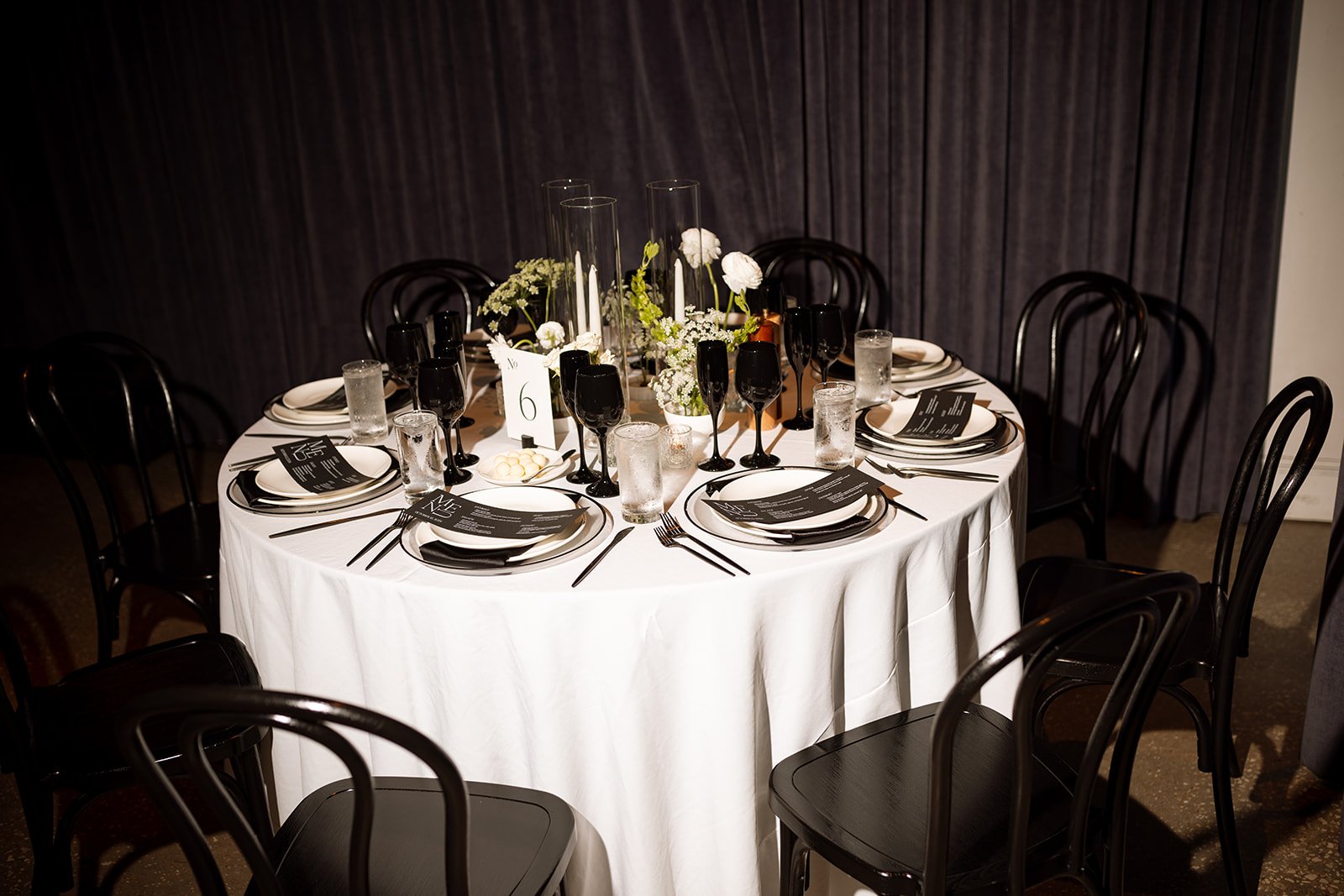 Wedding reception table featuring custom menus and place cards designed as part of the event branding.