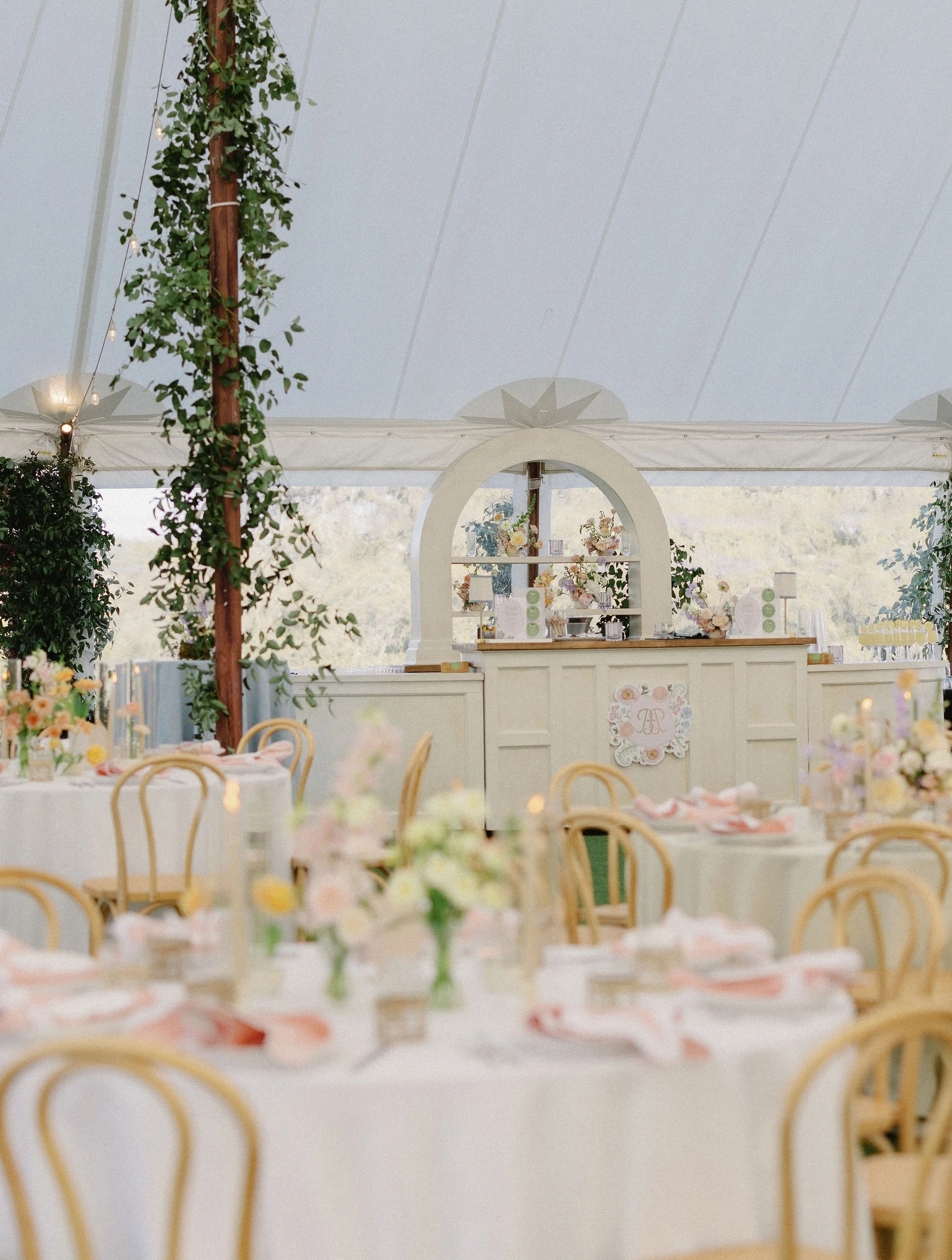 Wedding reception with custom event details, floral arrangements, and layered table settings.