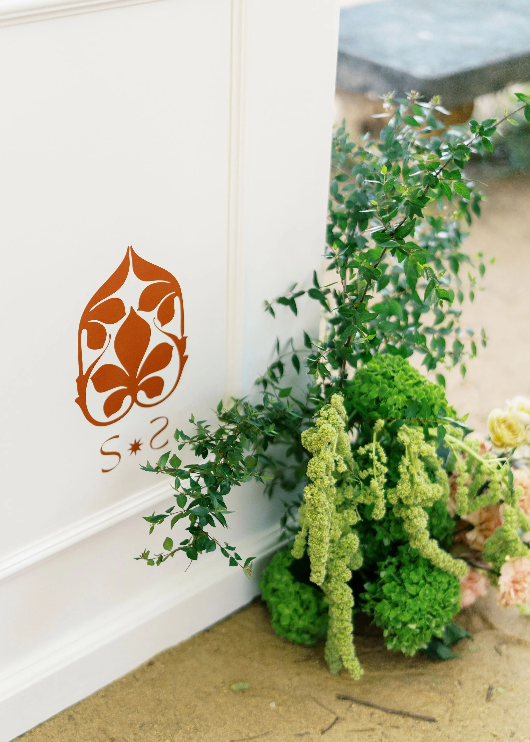 Custom illustrated event signage surrounded by botanical styling and greenery.