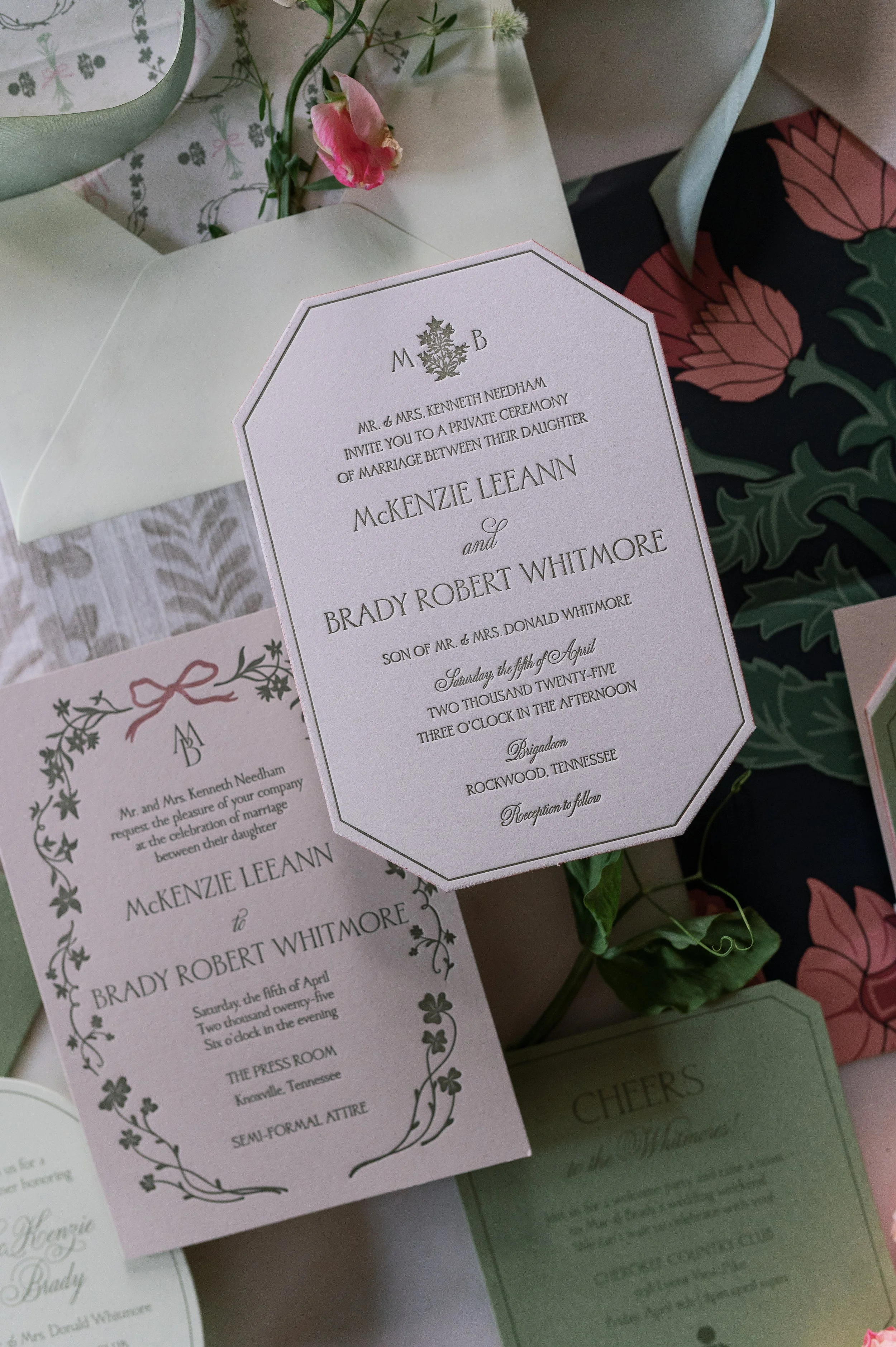 Wedding invitation card with details of the marriage ceremony between McKenzie Leann and Brady Robert Whitmore, including the date, time, location, and dress code, decorated with floral and botanical designs, surrounded by flowers and additional stationery.