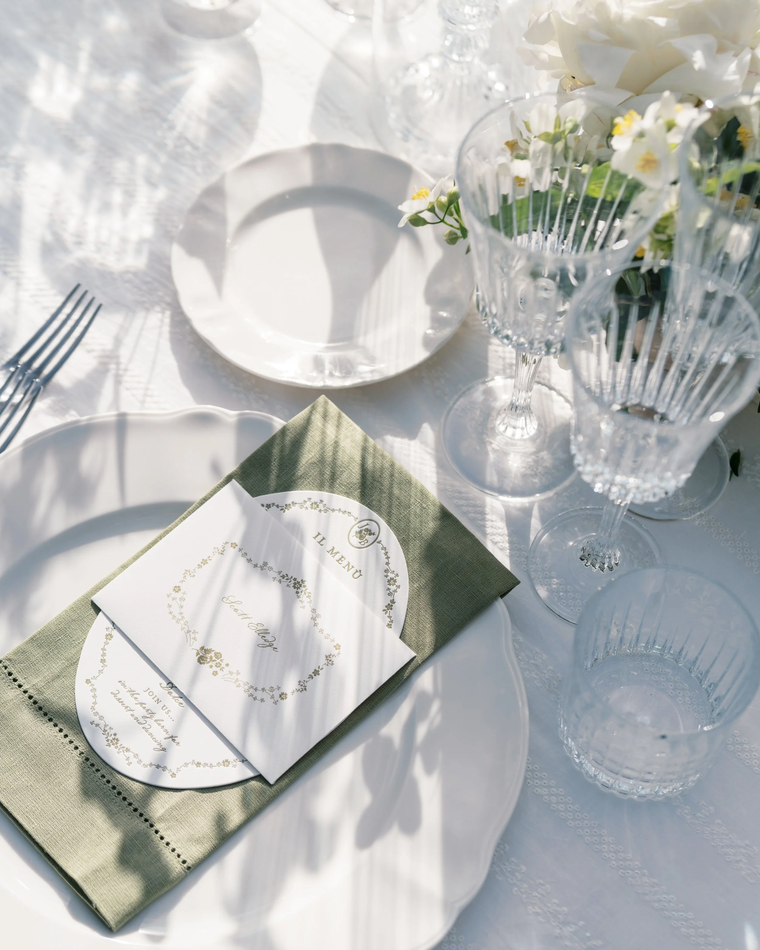 Custom wedding menu designed by Merci Studio within a layered destination wedding place setting.