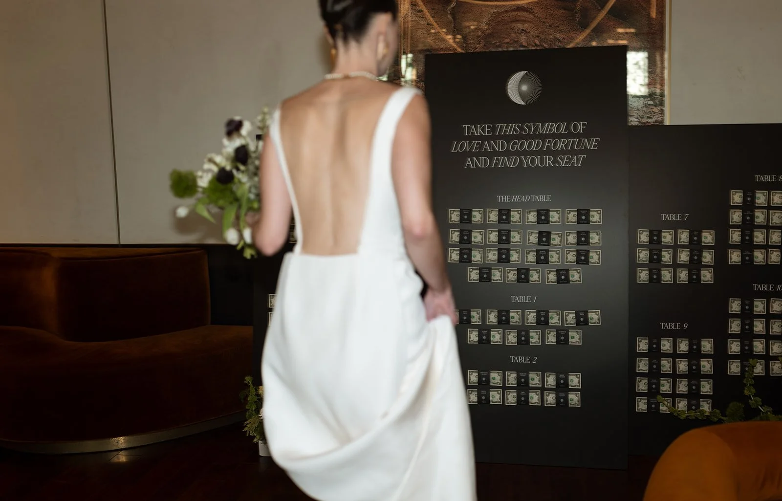 Bride beside a custom wedding seating chart designed as part of the celebration’s event branding.