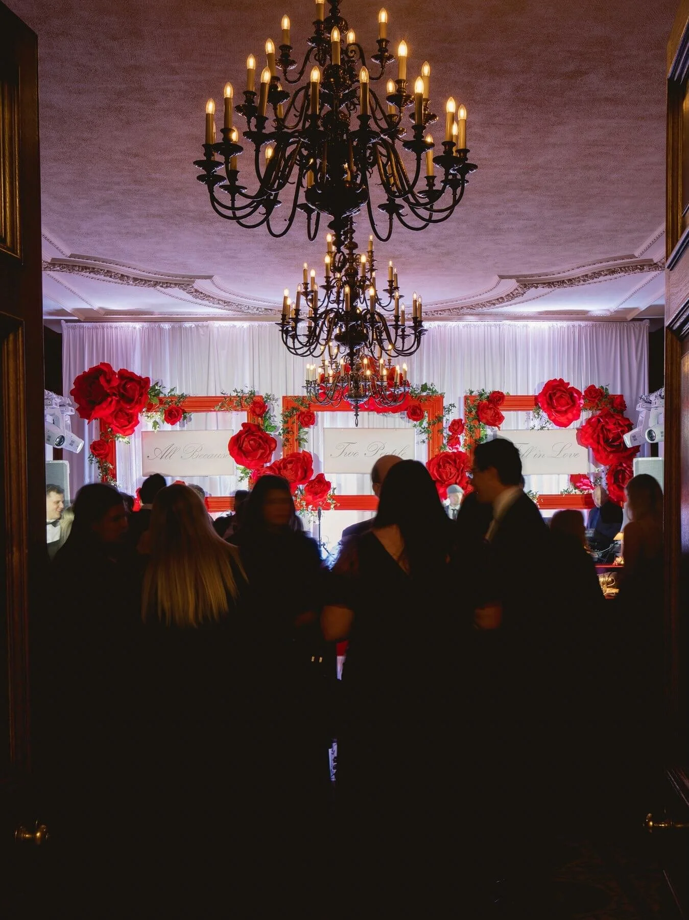 Luxury Pittsburgh wedding reception with warm pink uplighting and floral decor at the Duquesne Club