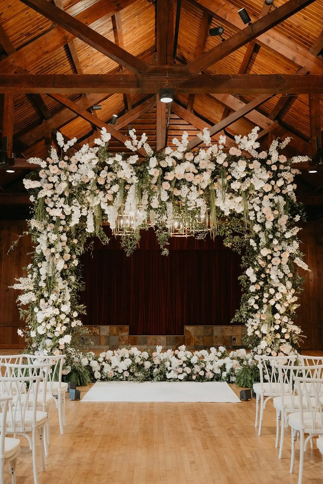 Floral arch  wedding ceremony decor illuminated with warm uplighting at Oglebay near Pittsburgh