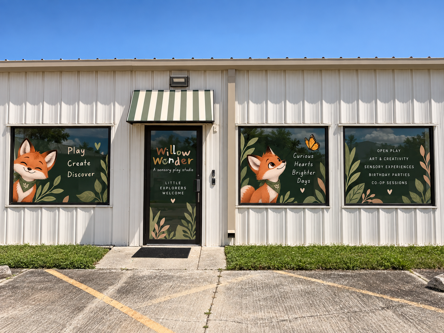 Front view of a white building with three large windows and a door, featuring illustrations of cartoon foxes and text promoting a sensory play studio called Willow Wonder, with phrases like "Play," "Create," "Discover," and "Curious Brighter Days," with a parking lot in front.