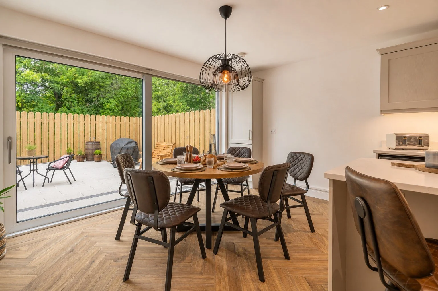 Dining area at The House – Bushmills with a table that seats six persons looking out onto the garden