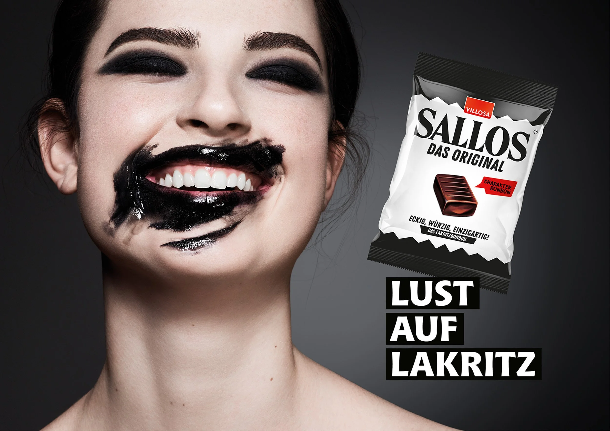Close-up portrait of a woman laughing with black eye makeup and black-smeared mouth, beside a Sallos licorice candy package.