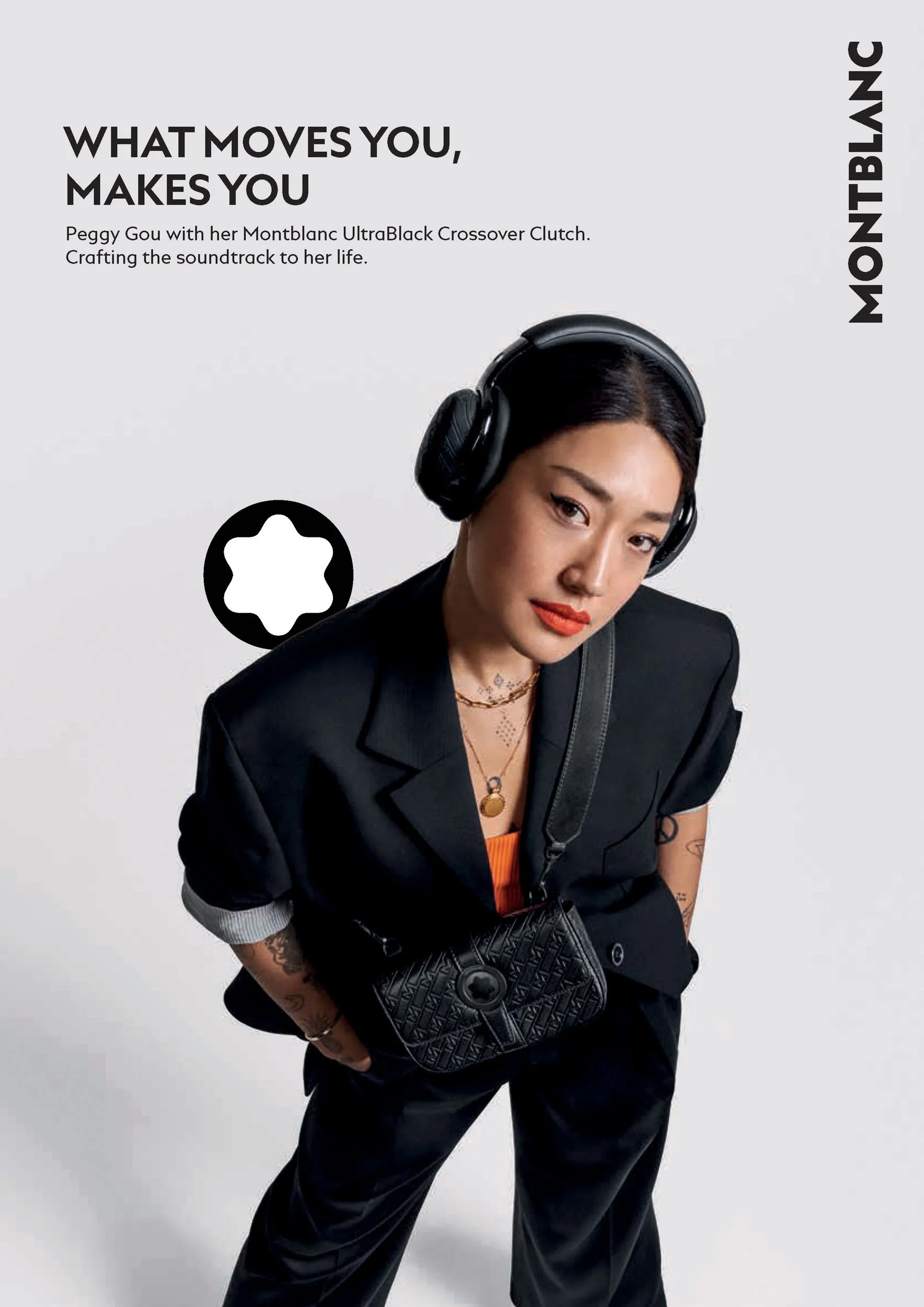 Woman in a black suit and oversized headphones carrying a quilted black clutch bag, with Montblanc logo.