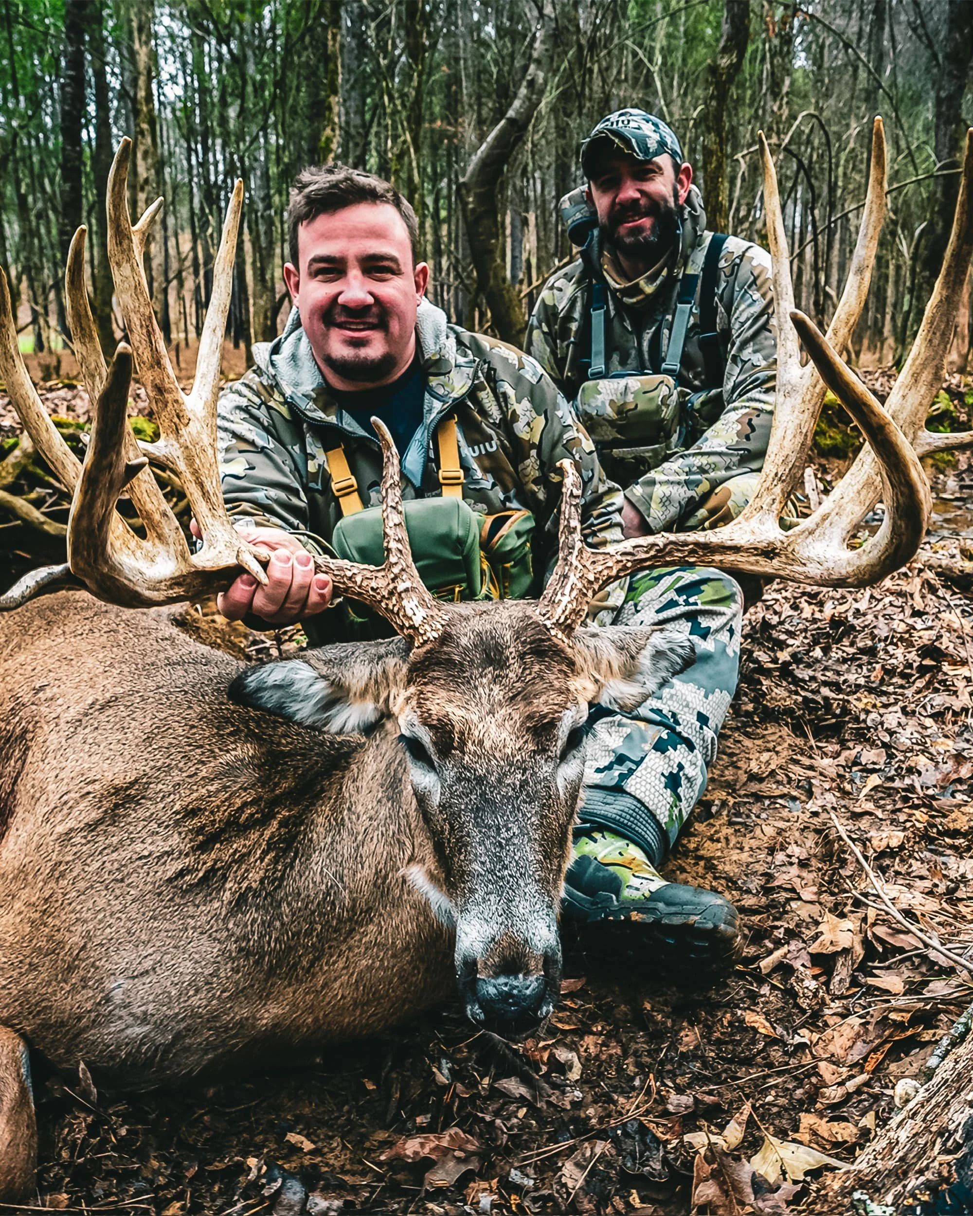 two hunters holding trophy worthy whitetail deer