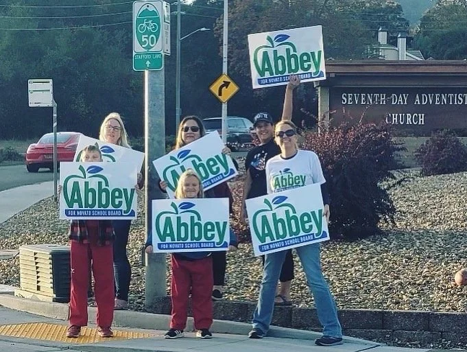 Abbey Picus with supporters holding Abbey for Novato school board signs.