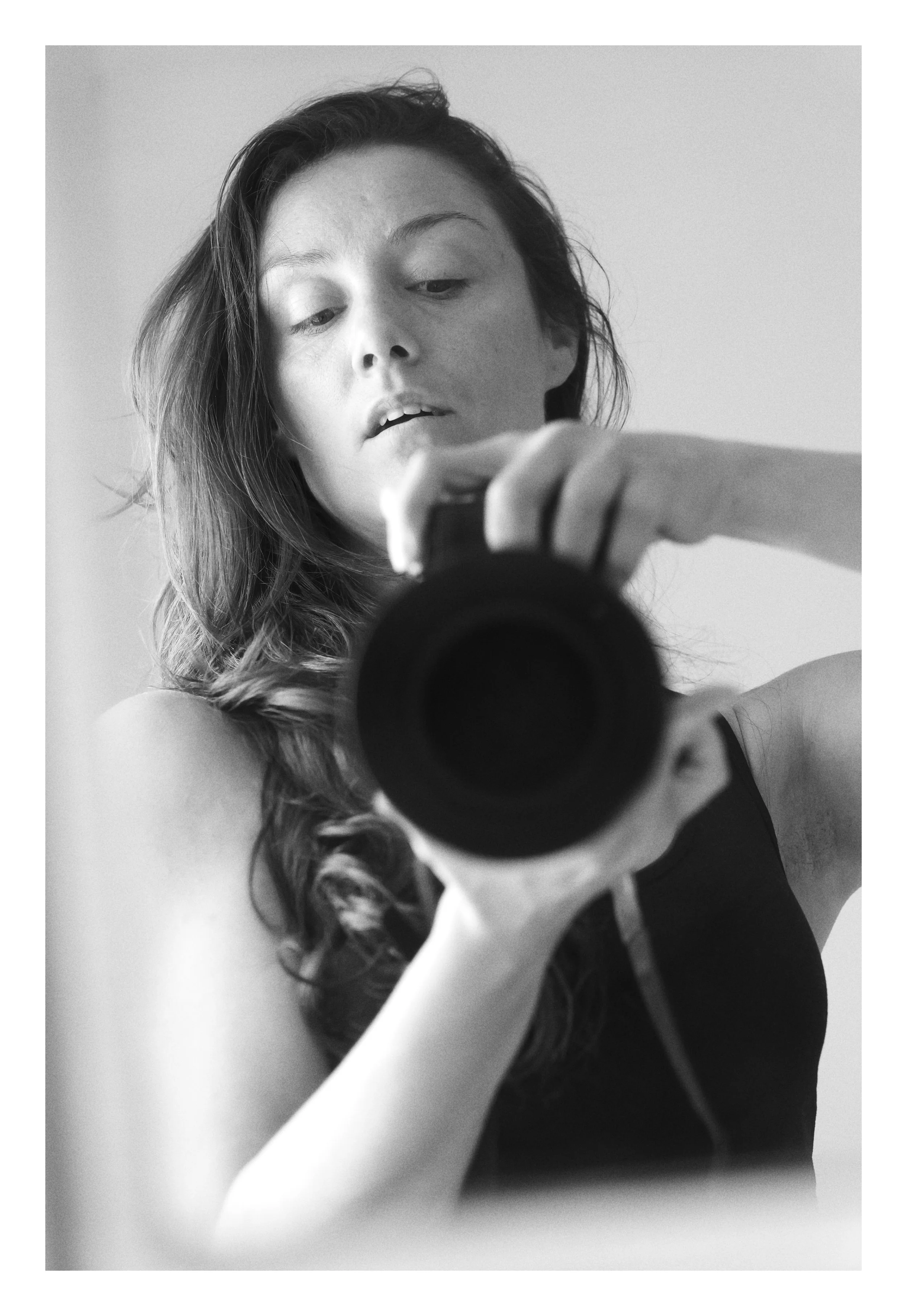 Jeune femme prenant un selfie avec un appareil photo reflex, visible dans le miroir