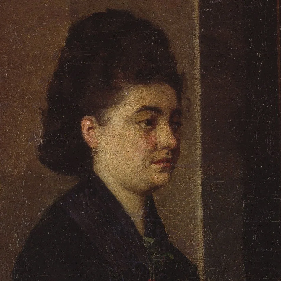 Ritratto di una donna con i capelli scuri raccolti in uno chignon, che indossa una blusa scura