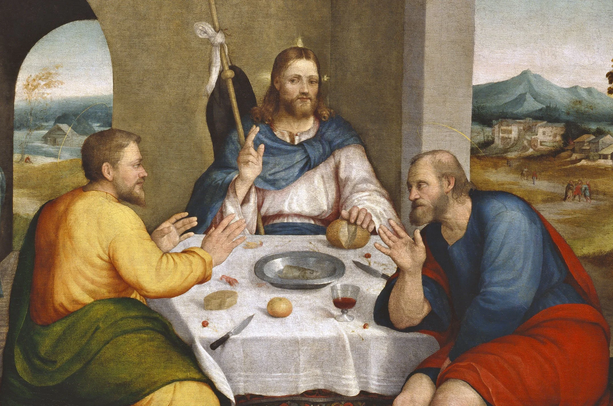 A religious painting depicting Jesus Christ among four men, seated at a table, with a scenic landscape with mountains and small buildings in the background.