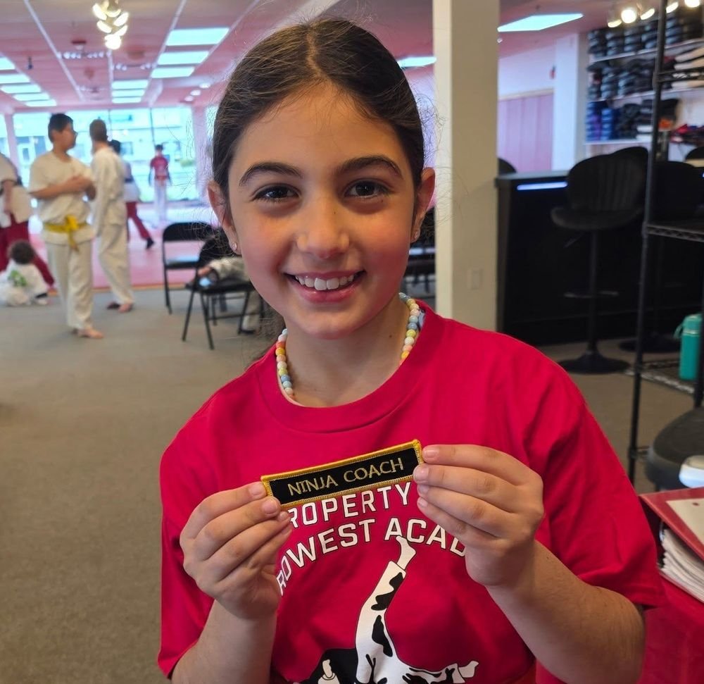 A Kids student holding the Ninja Coach patch she just earned at Metrowest Academy