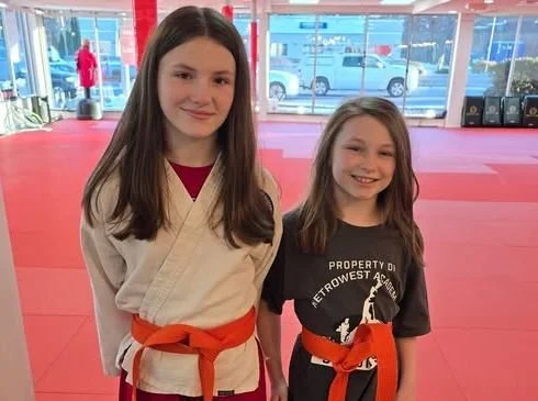 Two Apprentice-level Leadership Team students in orange belts at Metrowest Academy